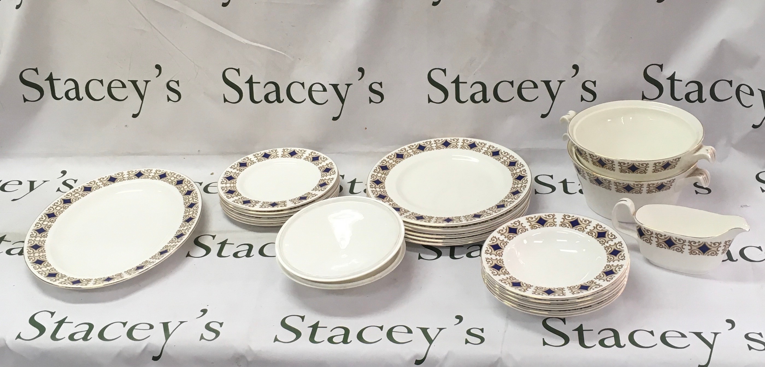 Vintage ceramic tableware featuring a cobalt blue design on the panels, floral elements, repeating interlocking circles, and a bright gold gilded trim. 