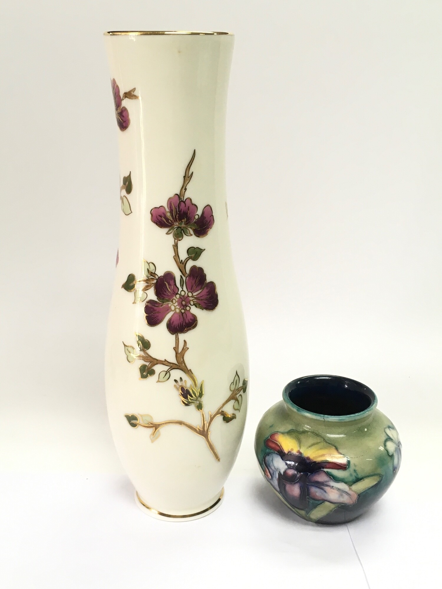 A small William Moorcroft orchid pattern vase, a/f, approx height 7cm together with a Zsolnay Pecs vase of waisted form, approx height 25cm, a Carltonware dish in the form of a leaf and an antique pot lid (4) NO RESERVE