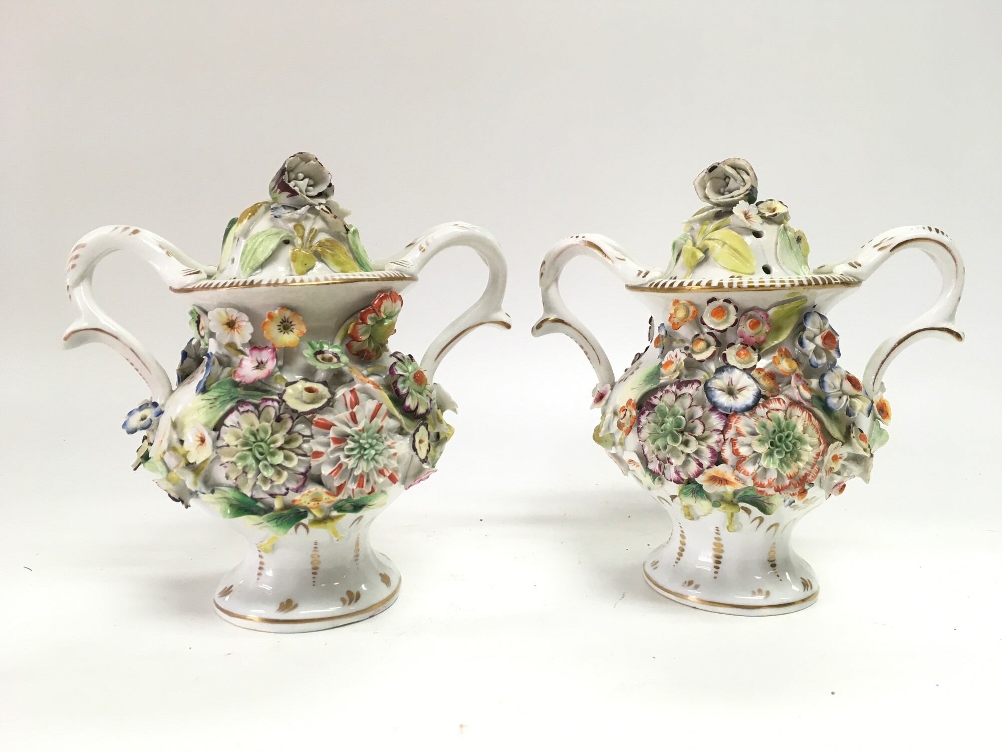 A pair of porcelain pot pourri with floral decoration. 16cm tall