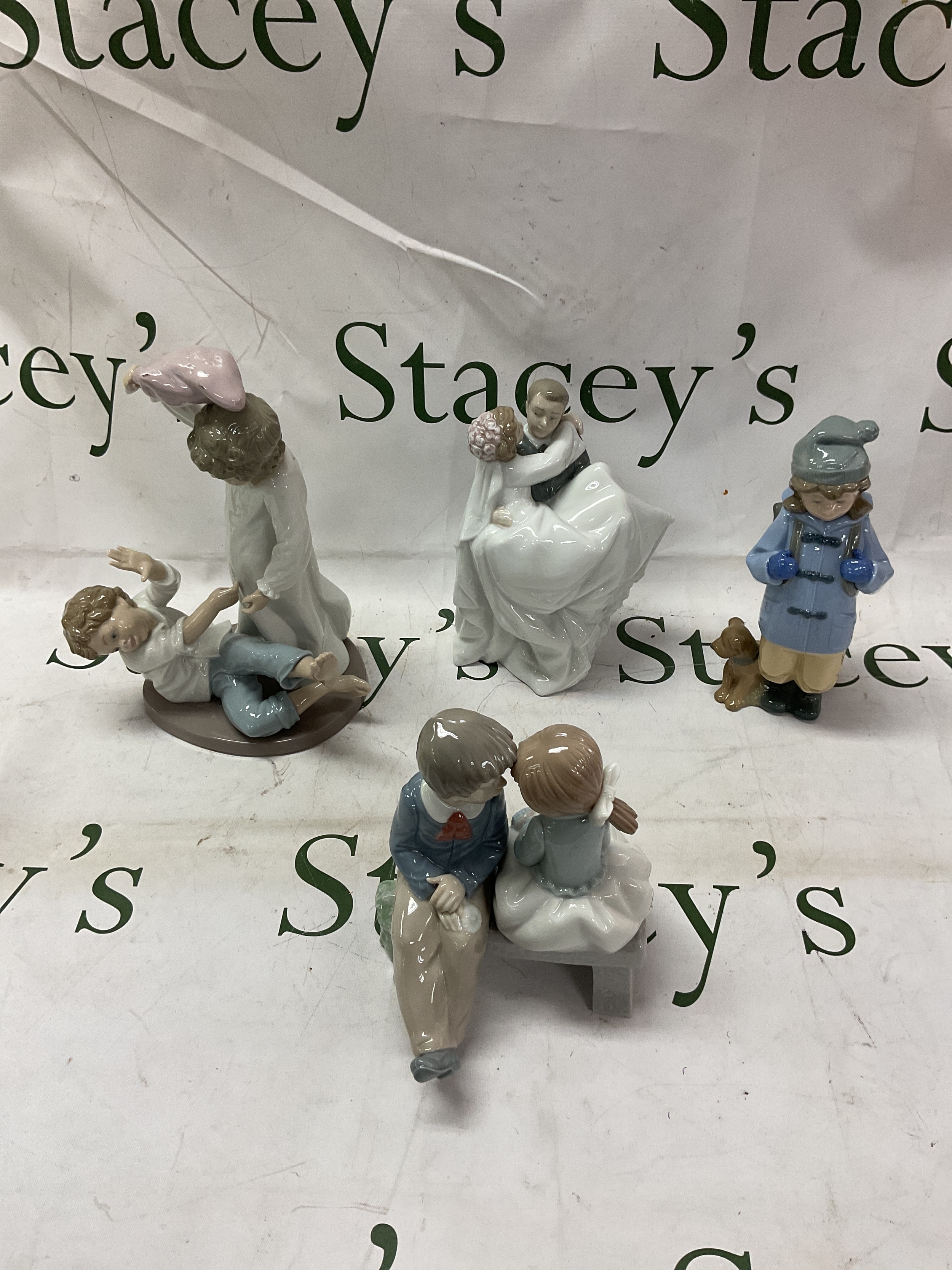 Four NAO figurines, pillow fight, love seat, girl and dog and bride and groom.