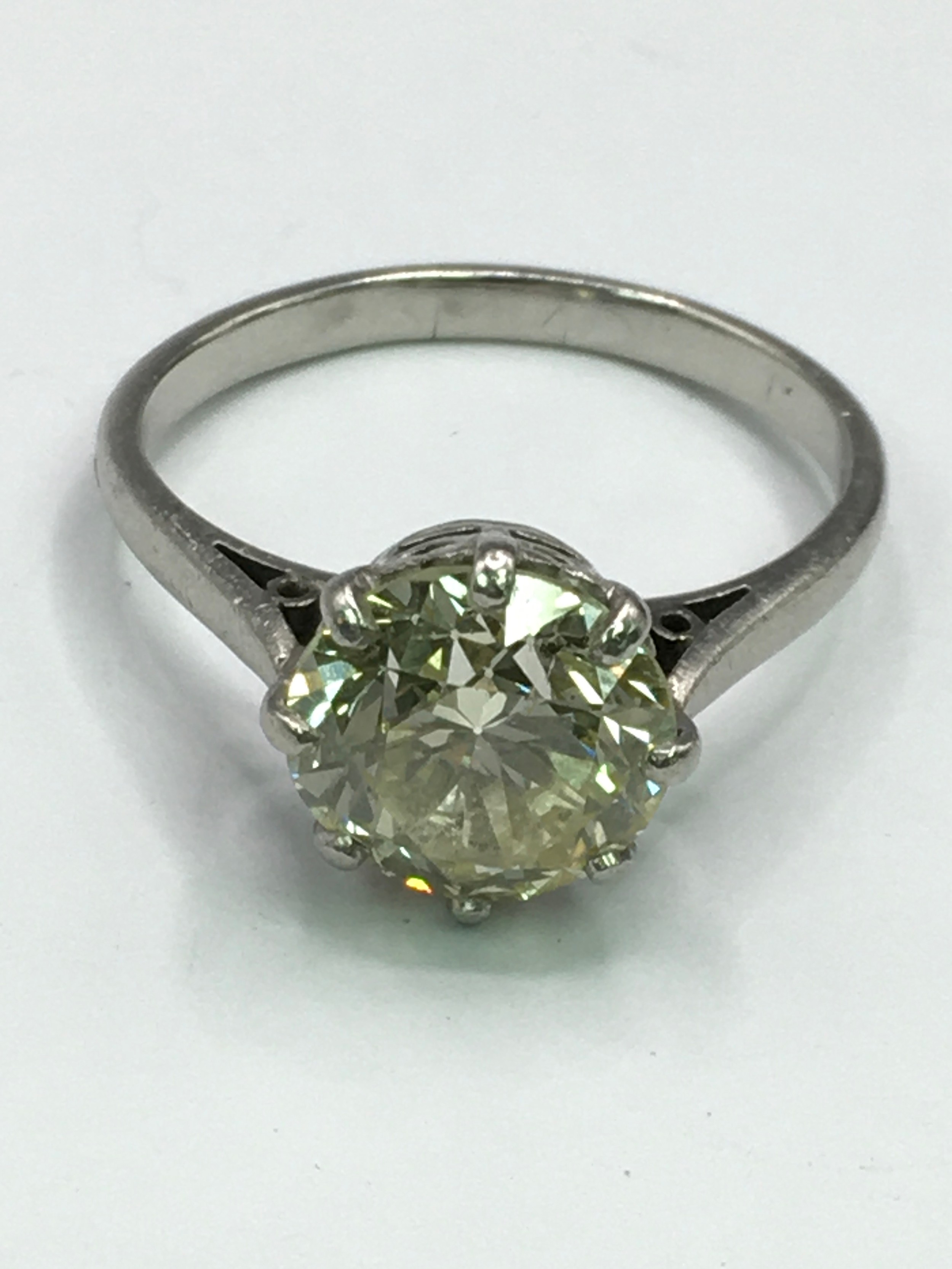A fine, antique tinted yellow diamond solitaire ring. Claw set on white metal band, stamped Plat. Approx 3.32 carat, assessed clarity SI1./S12, assessed  colour L/M, 4.55 grams. Approx size M/N, stone measurements 9.24-9.41 x 6.01mm