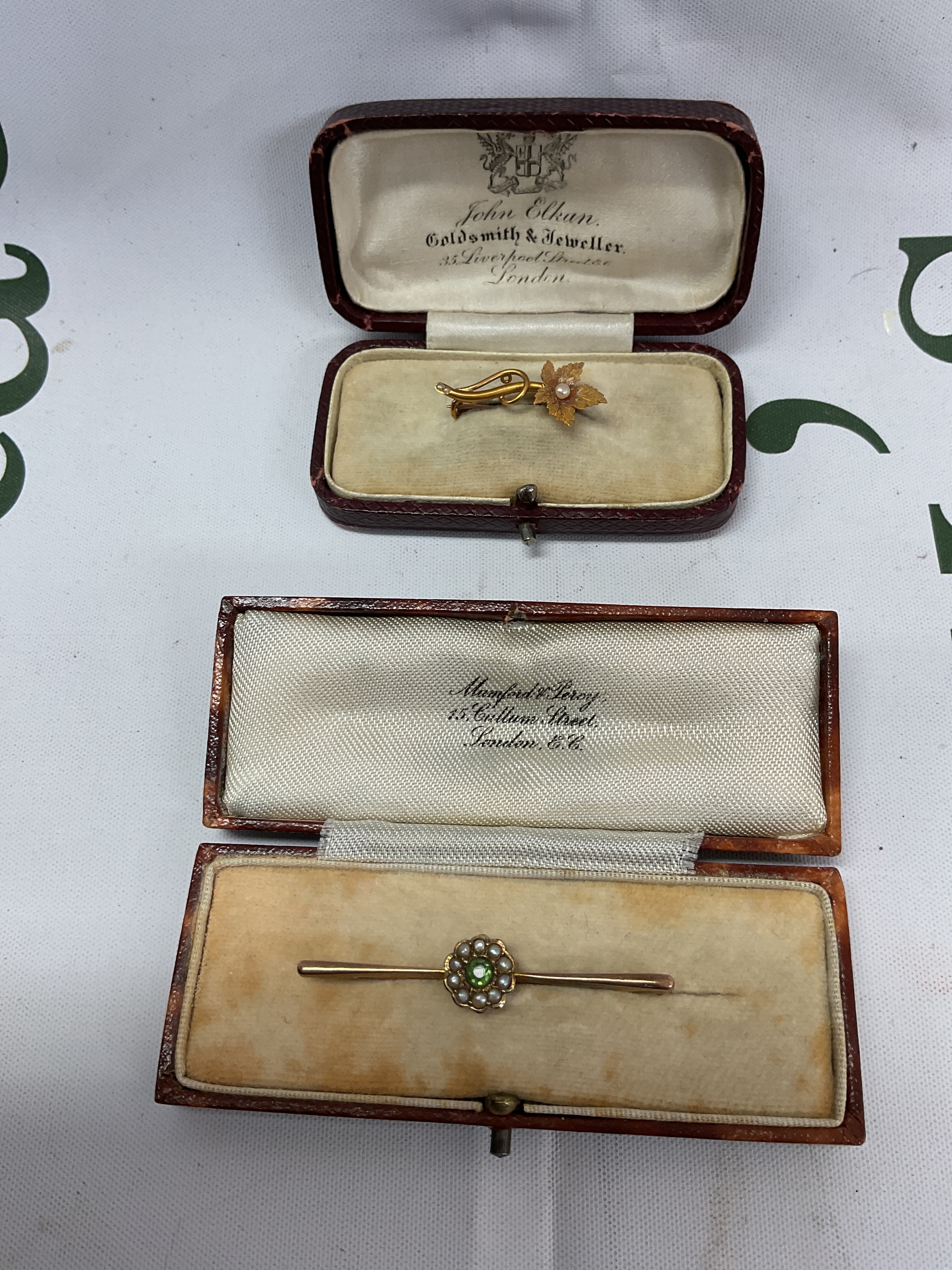 Two cased gold brooches the flower and pearl example in 15 ct gold 1.5 grams, the other in 9 ct 3.4grams.