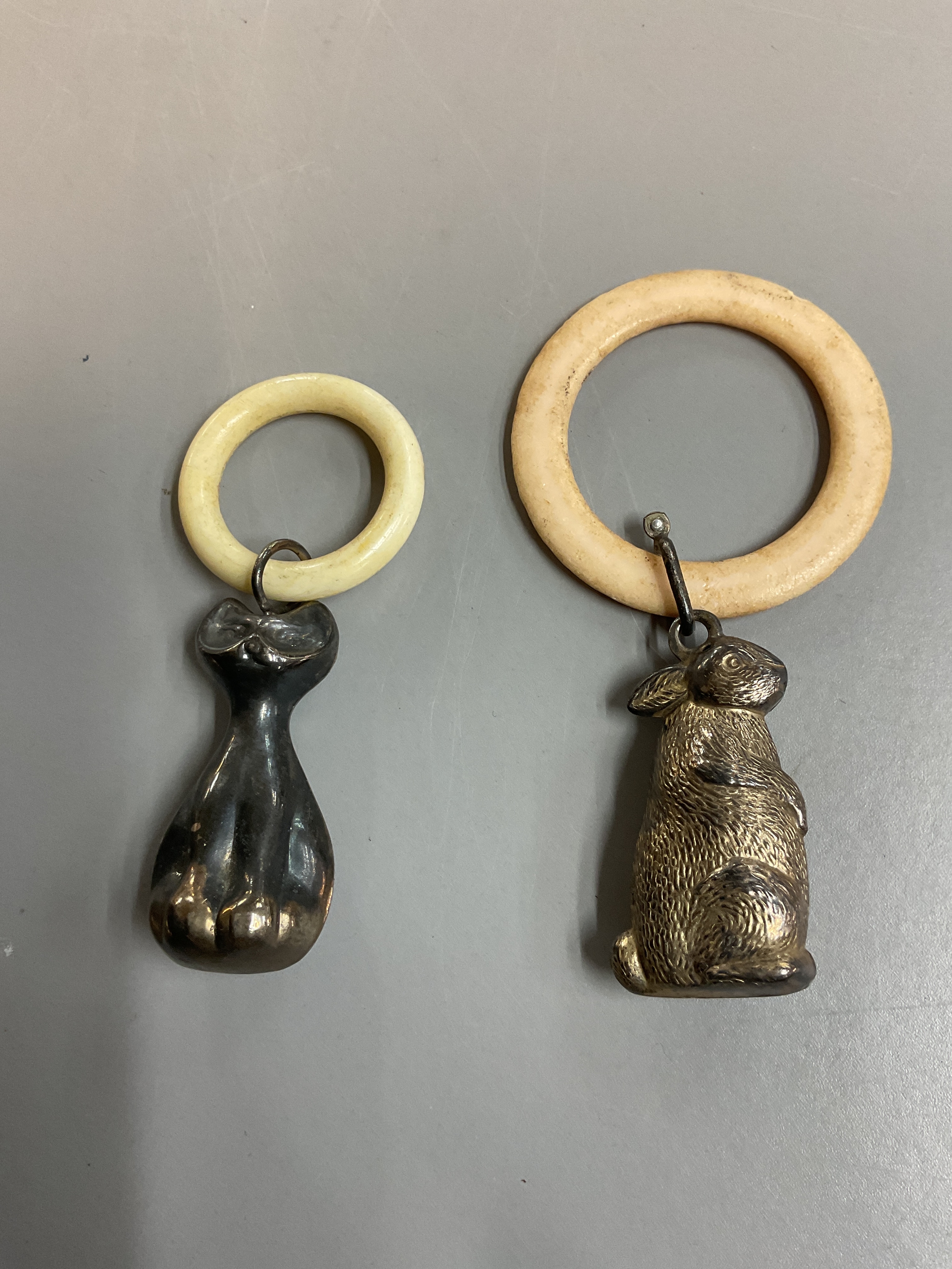 Two vintage teething rings, one of a rabbit the other of a stylized cat.