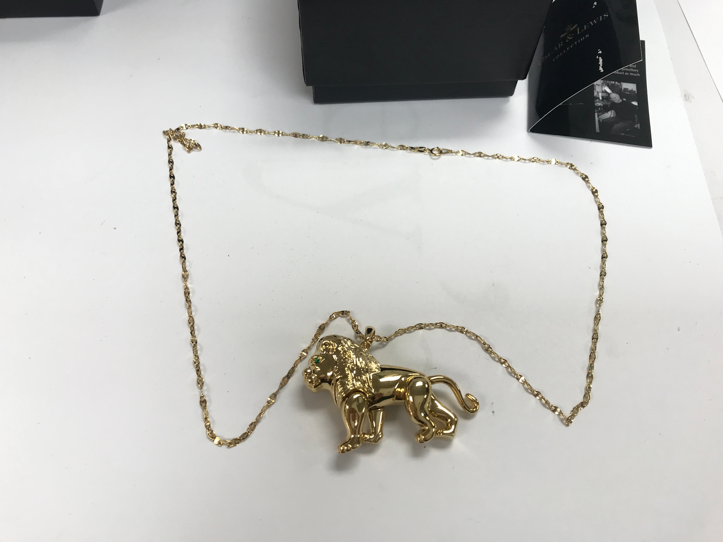 An Oscar and Lewis gold plated lion on a 9ct gold chain.
