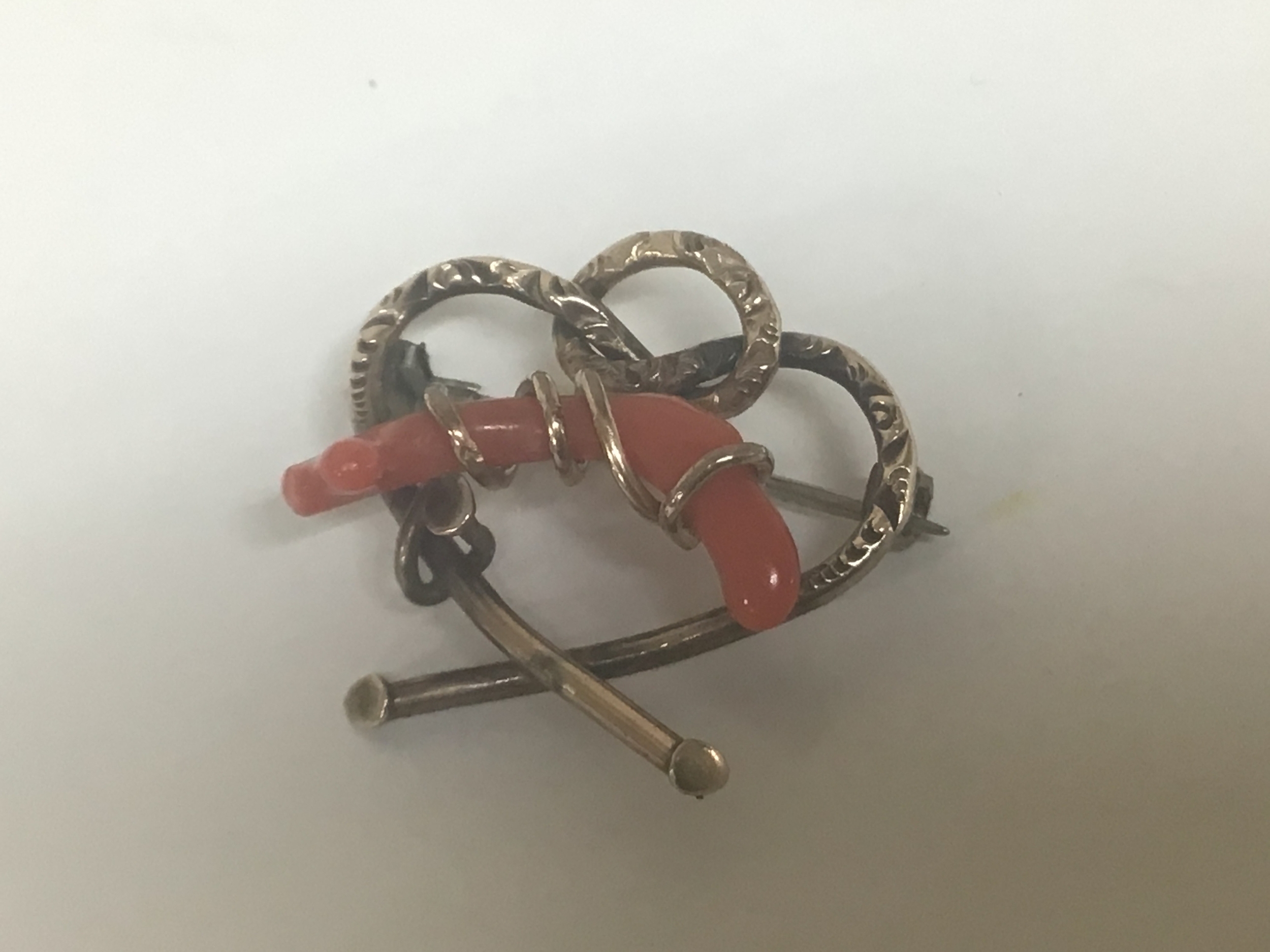 A brooch mounted with Coral yellow metal unmarked weight 2.4g