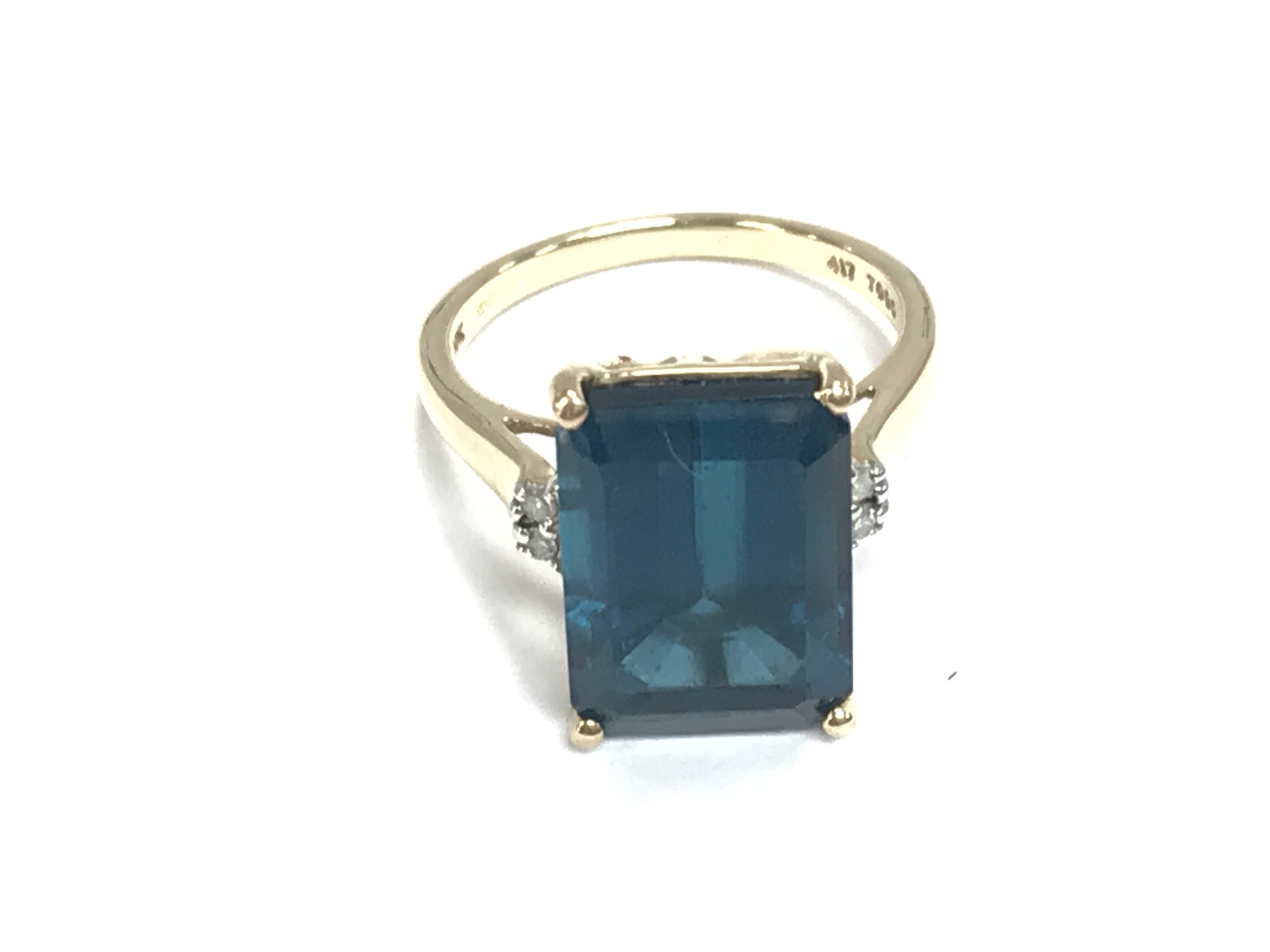 9ct gold ring with emerald cut topaz stone flanked by white stone accents. Size N 1/2 and 4.9g