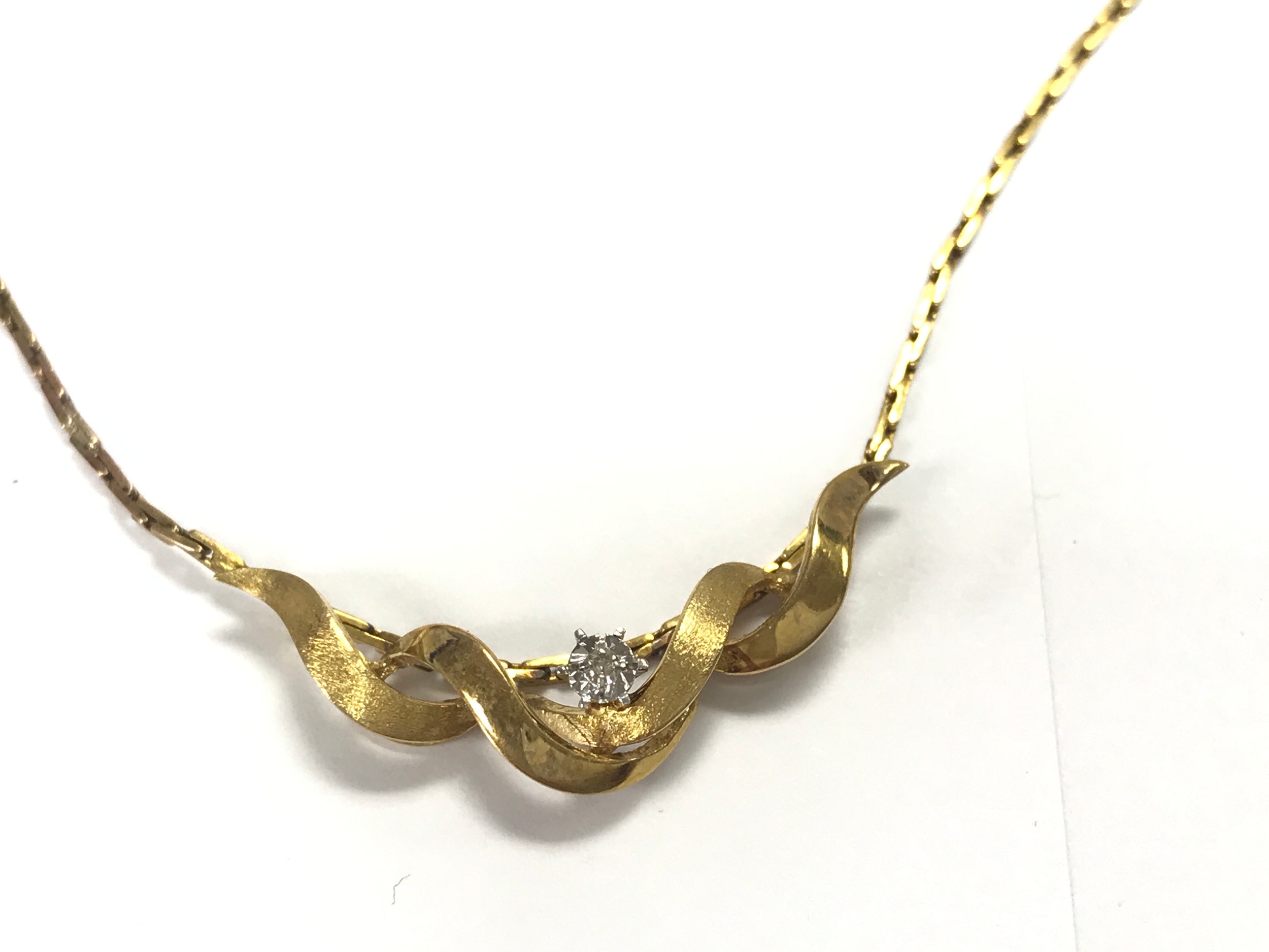 A 9ct gold necklace set with white sapphire. 5.7g