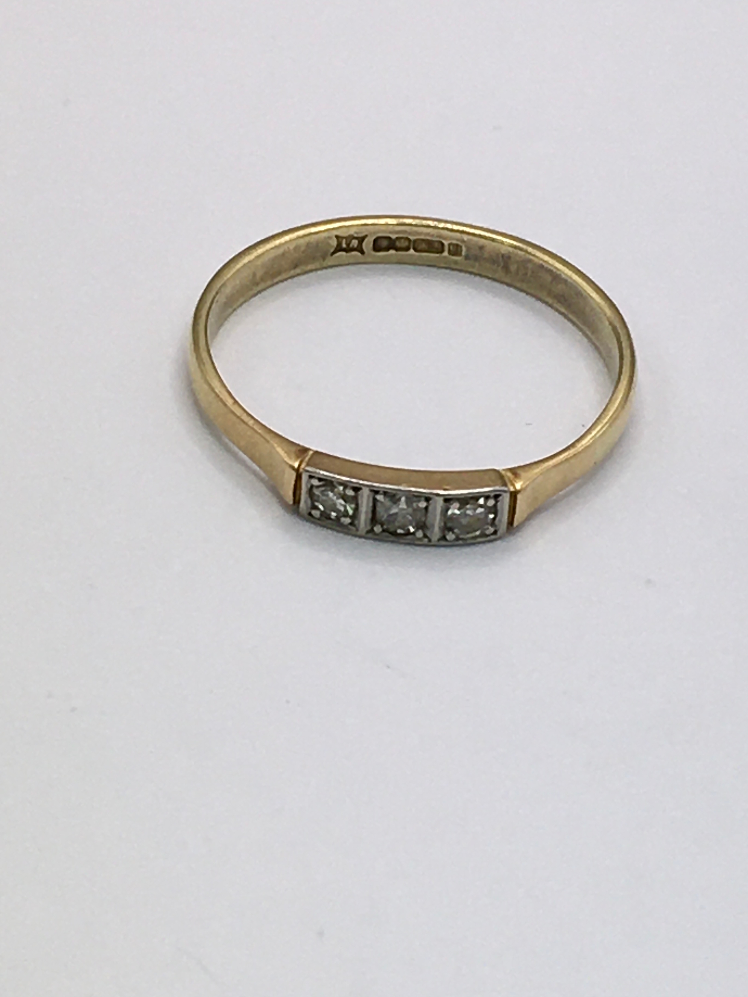 An 18ct gold ring having square mount set with three small diamonds. Approx size Q. 