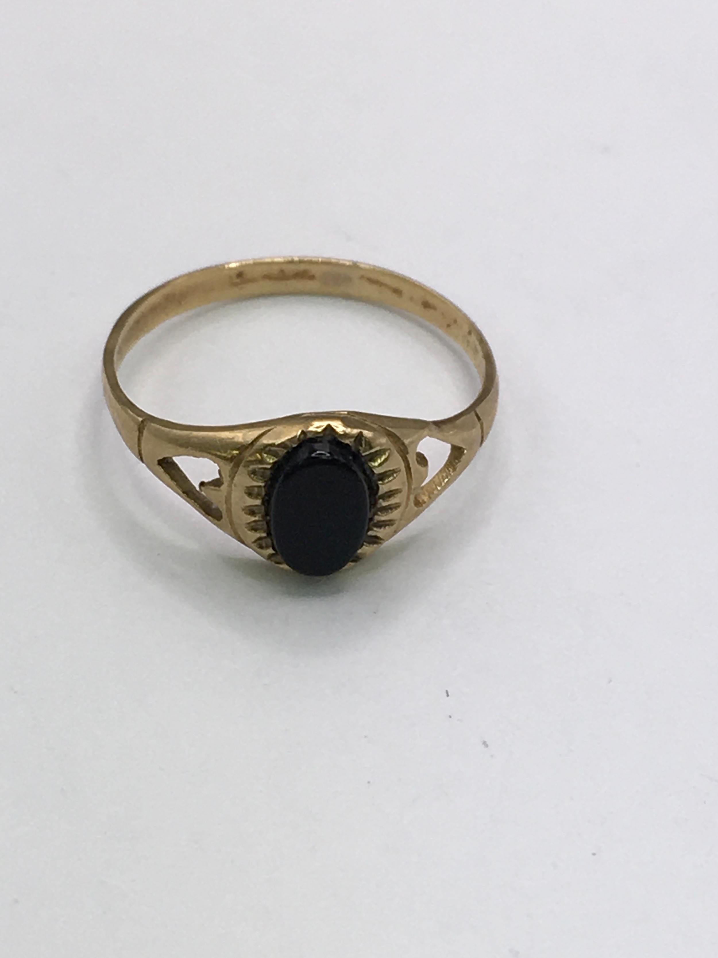 A 9ct gold, child's ring set with onyx type stone. Approx size G, small size.