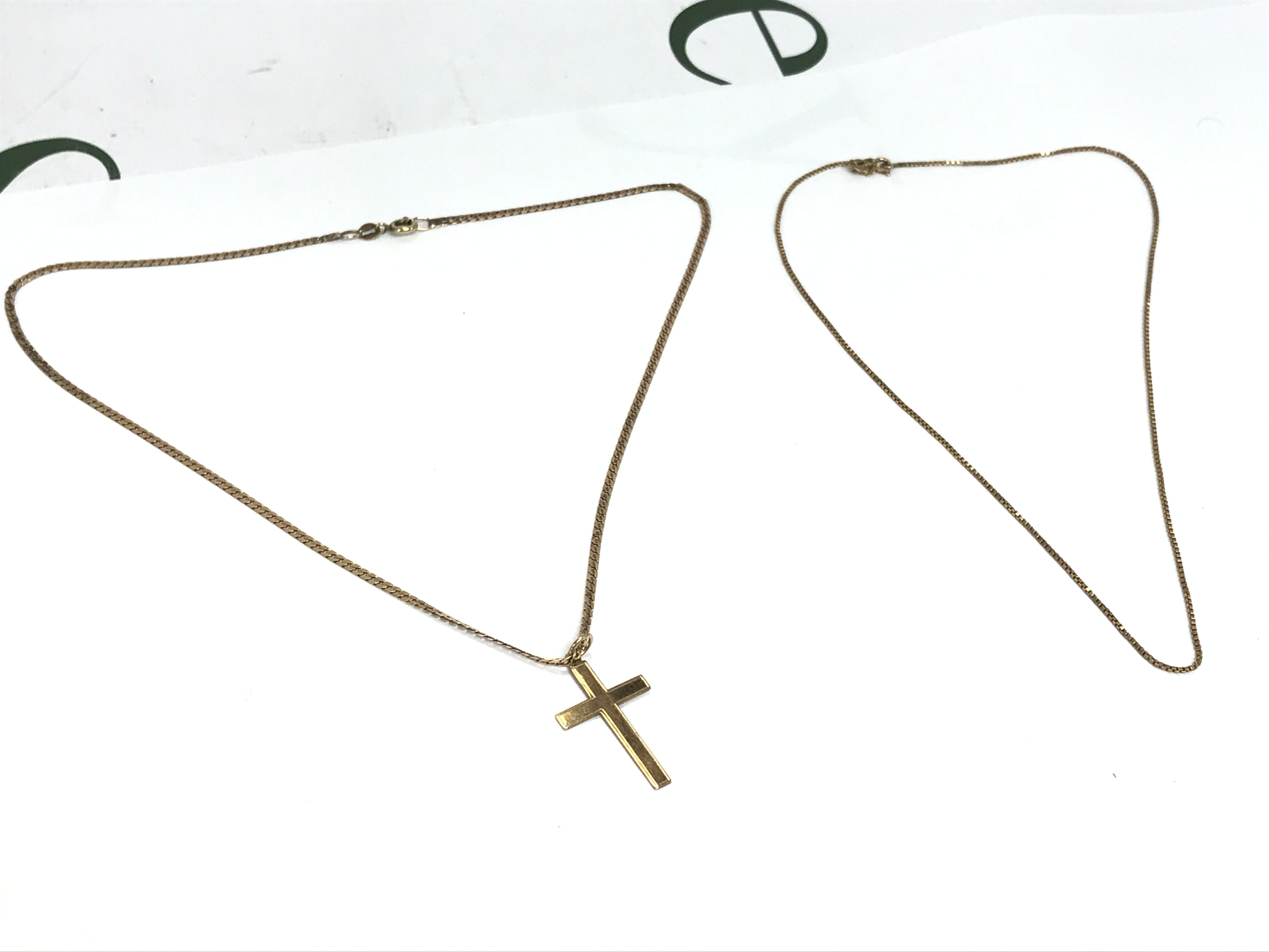 A thin 9ct gold chain (19cm long) and a 9ct gold chain (22cm long) with a 9ct gold crucifix pendant. 7.2g total weight