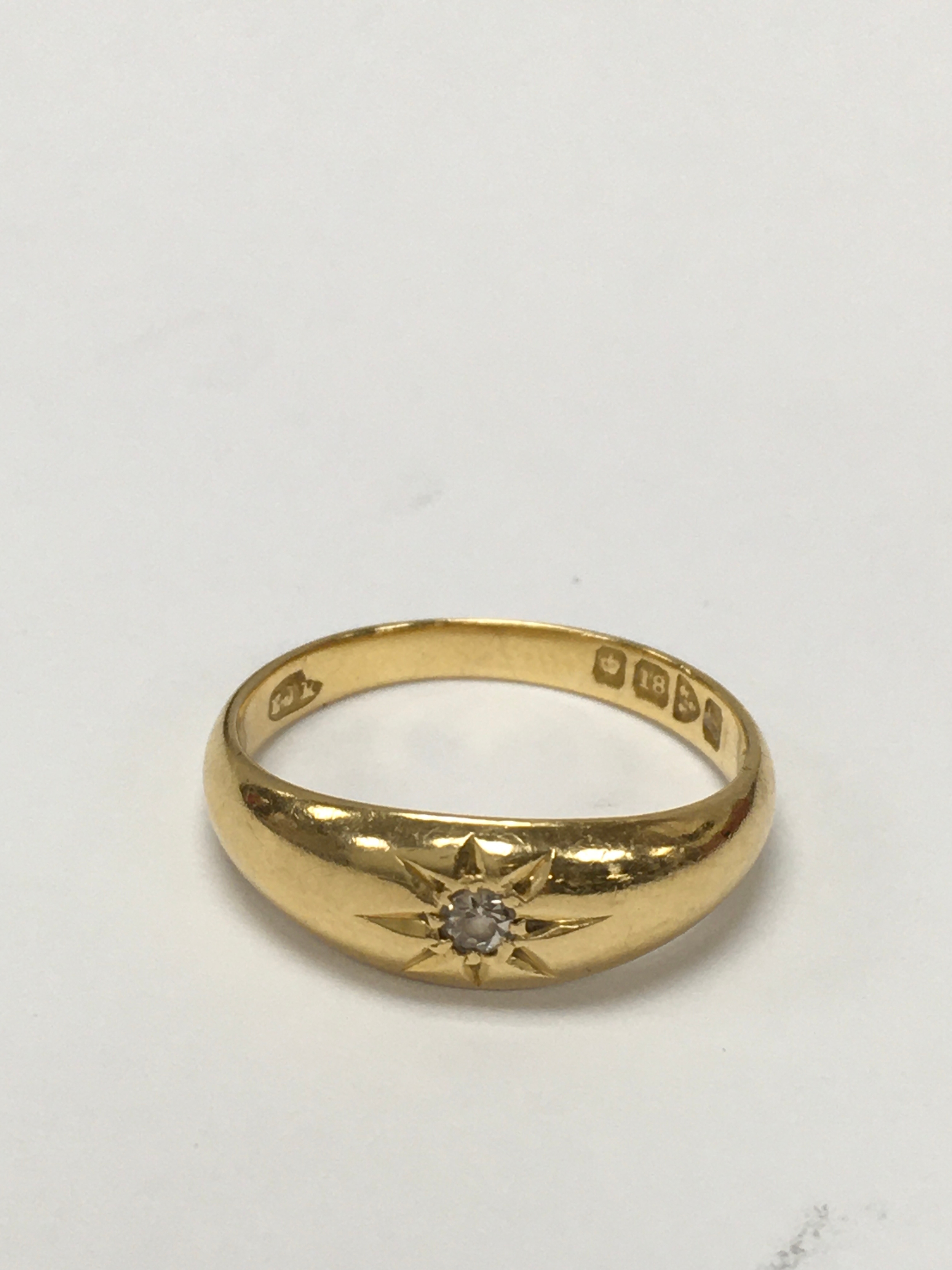 An 18ct gold gent's wedding ring, star set with a small old cut diamond. Approx size P.