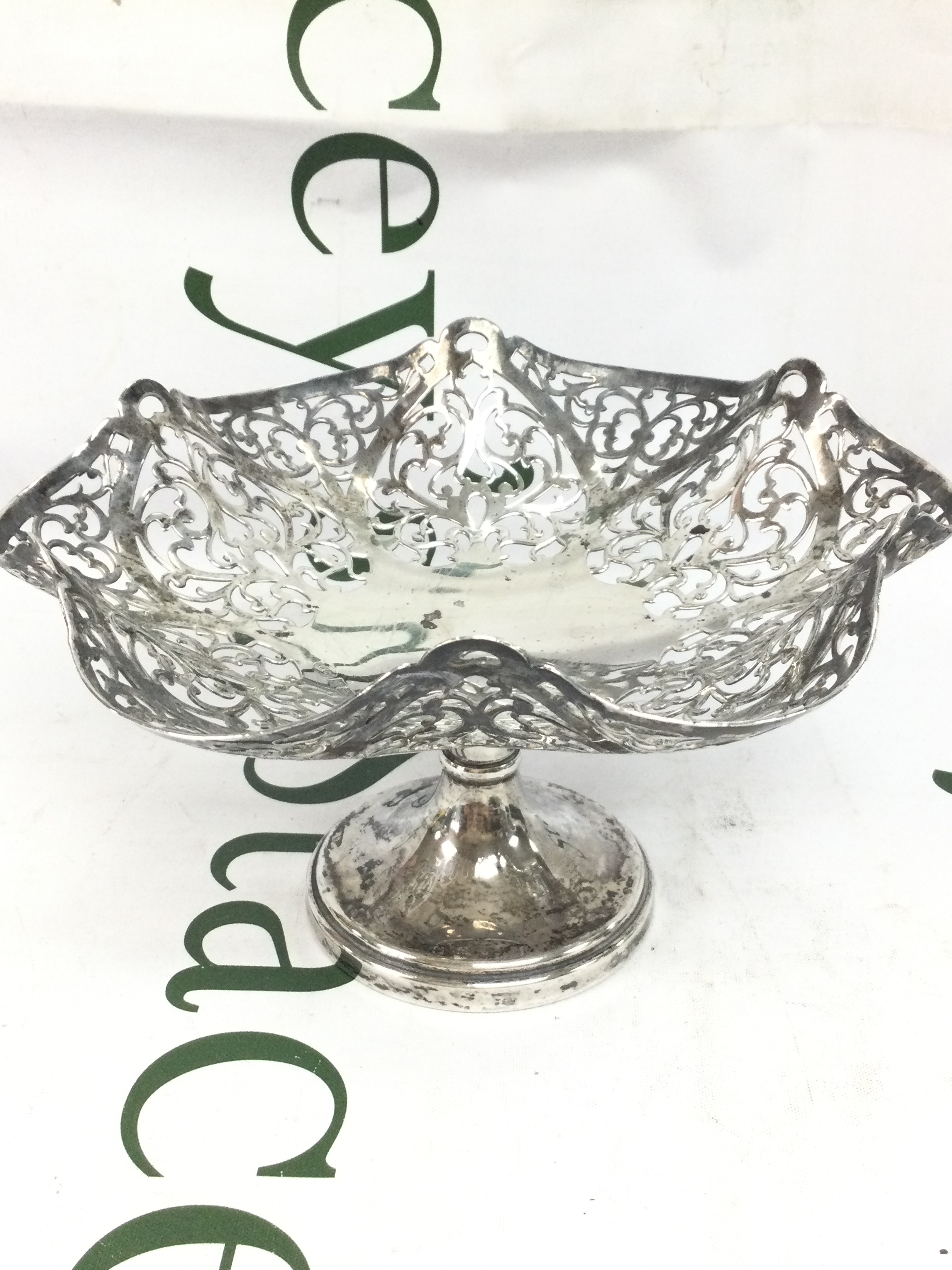 A silver hallmarked pedestal display bowl featuring a delicate pierced openwork design along its scalloped rim. 10cm tall 18cm wide. 225g total weight