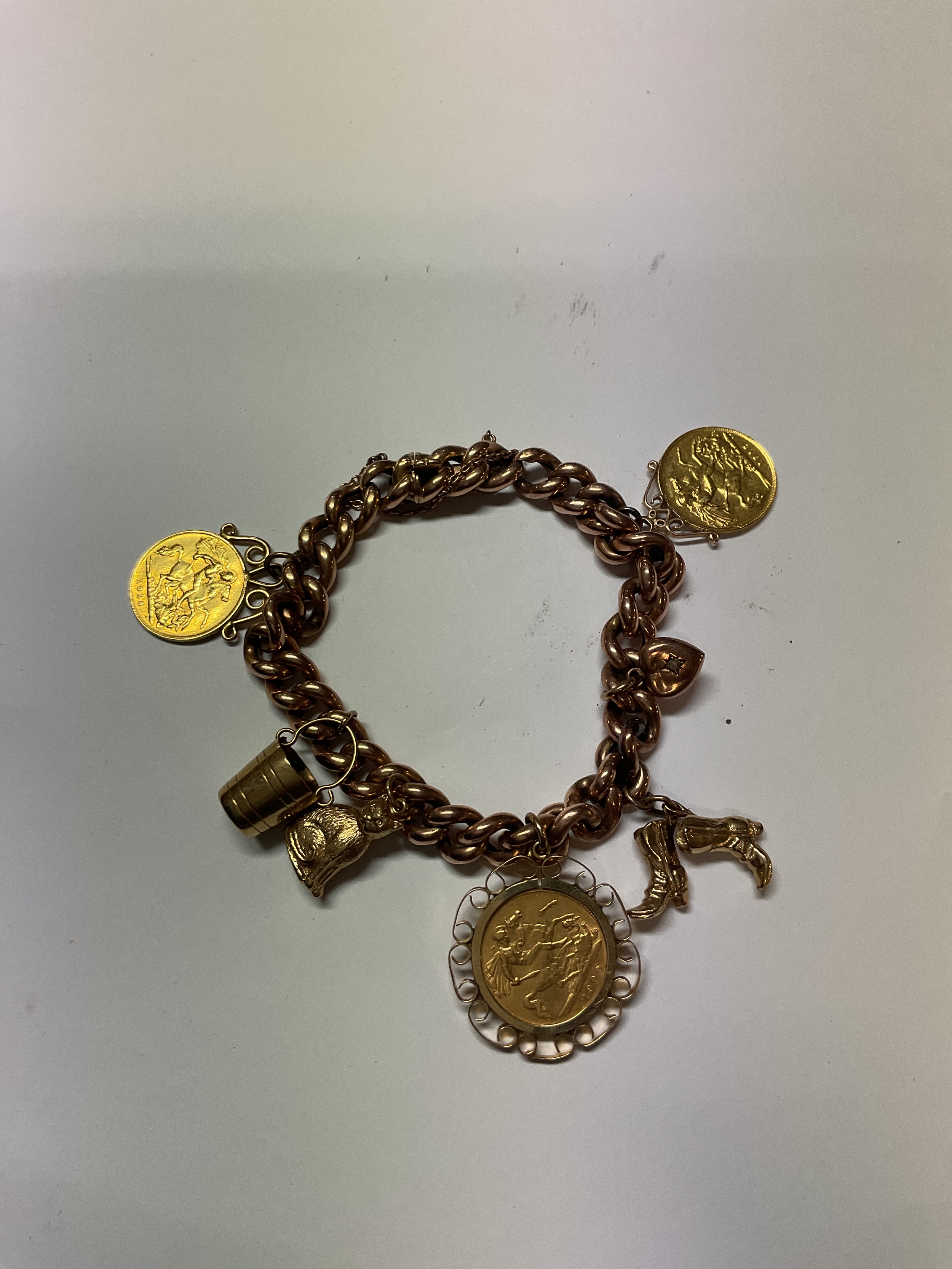 9 ct charm bracelet with three half sovereigns Weight 38 grams