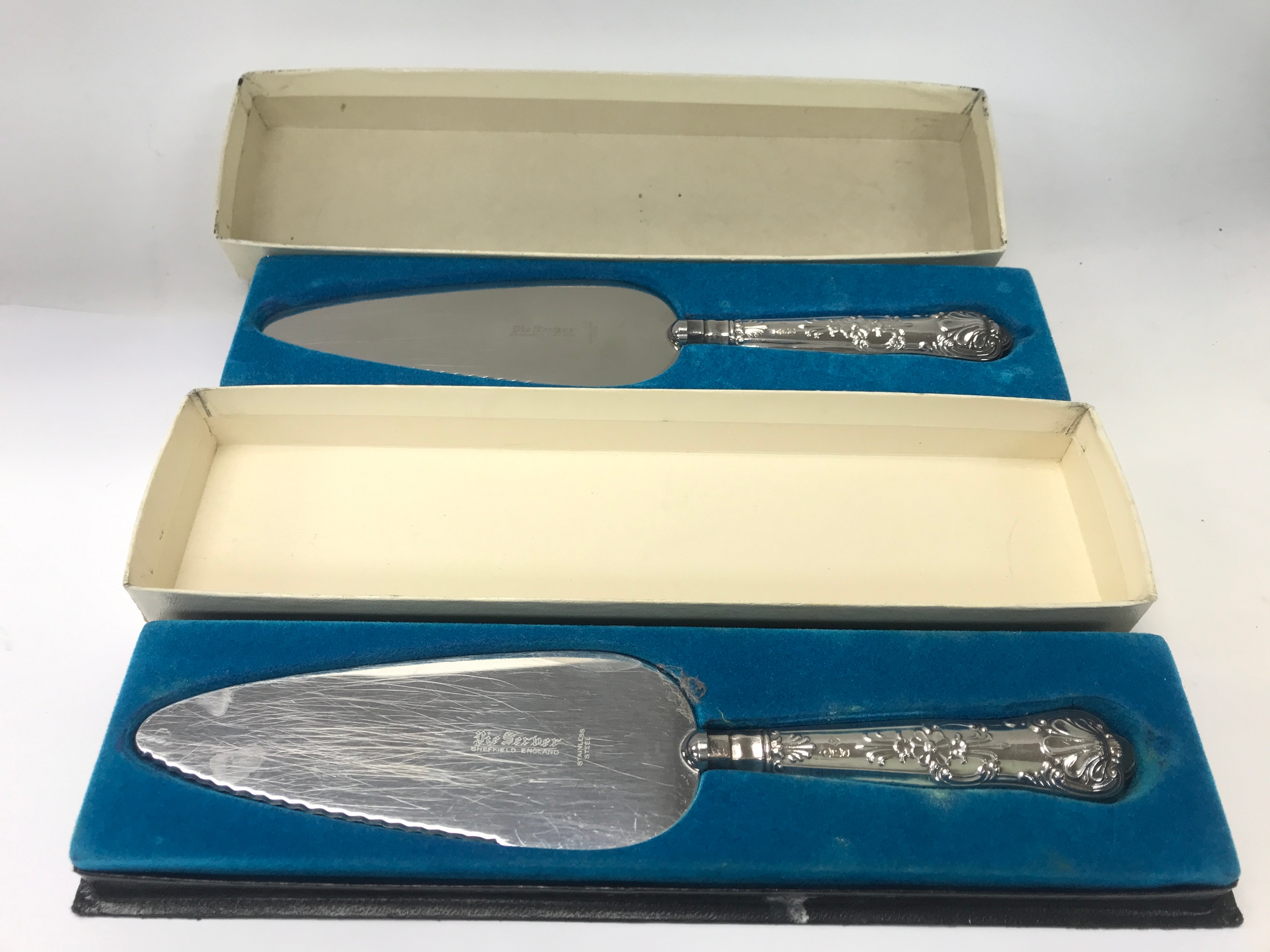 Two silver handled cake slices.
