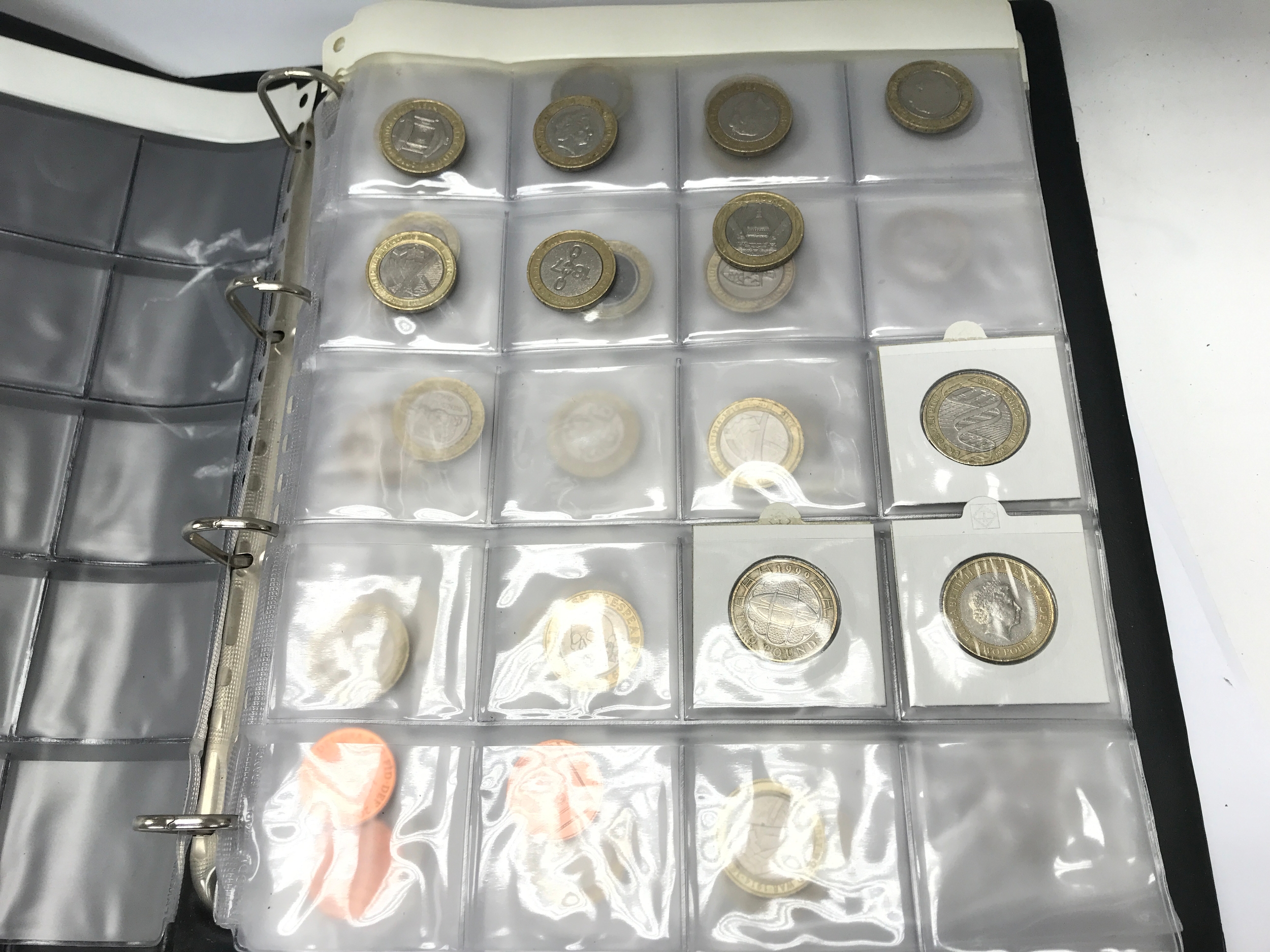 A collection of various £2 and 50p in a folder.