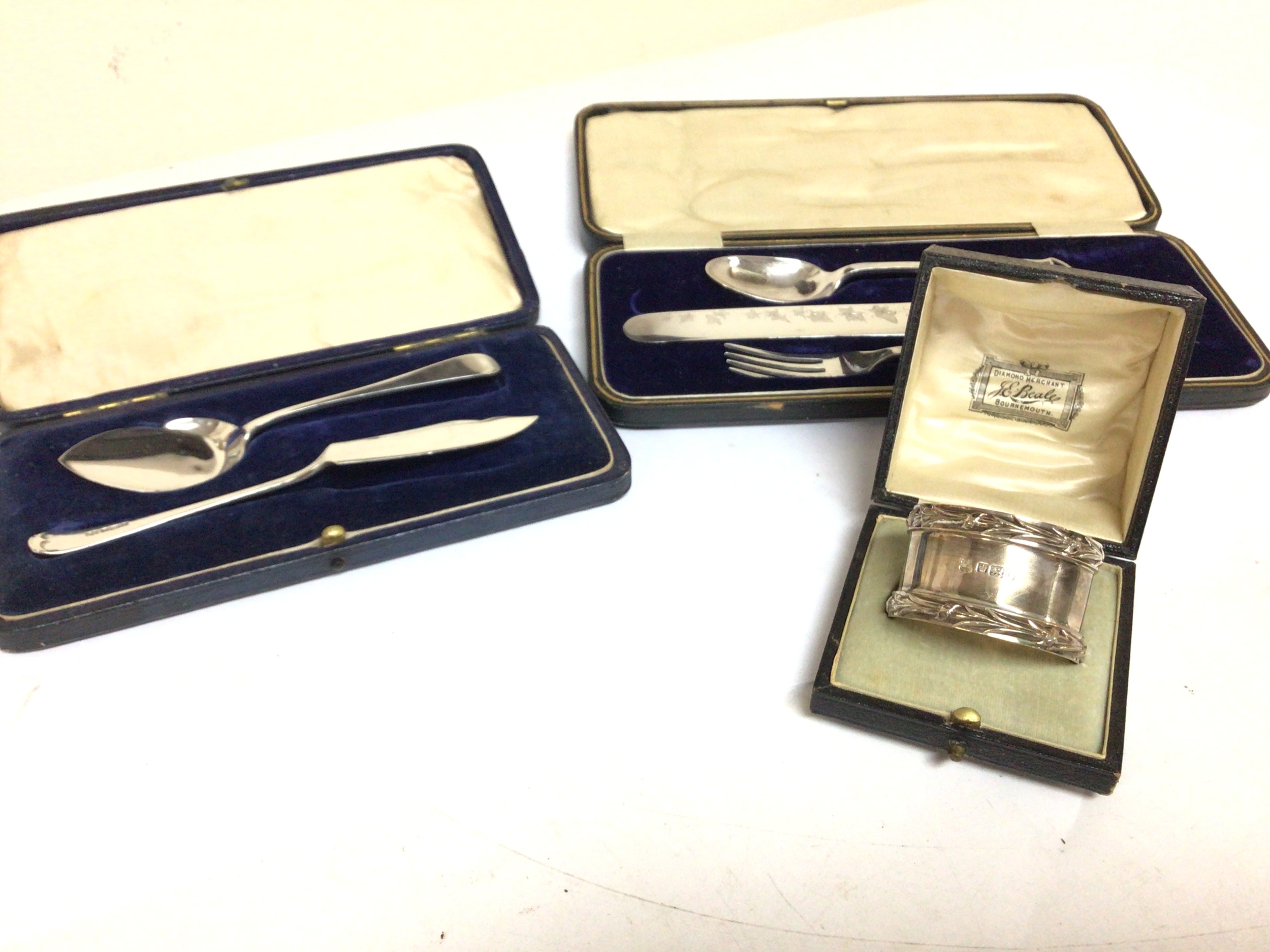  Two cased silver and plated cutlery serving spoons knife annd folk set  and a silver napkin ring in a fitted case. 