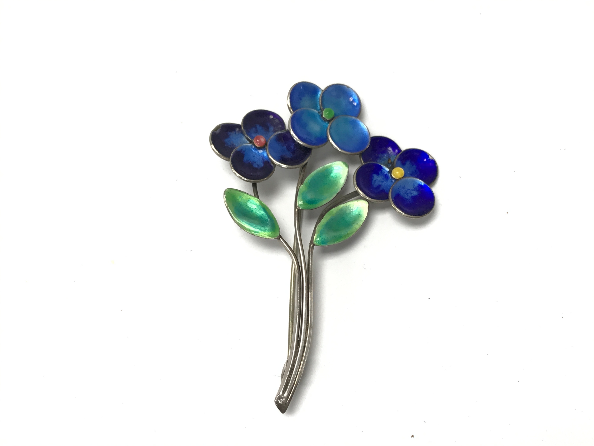 vintage Bernard Instone Blue Enamel and Silver Floral Brooch featuring beautifully shaded deep blue enamel petals and vibrant green leaves.
