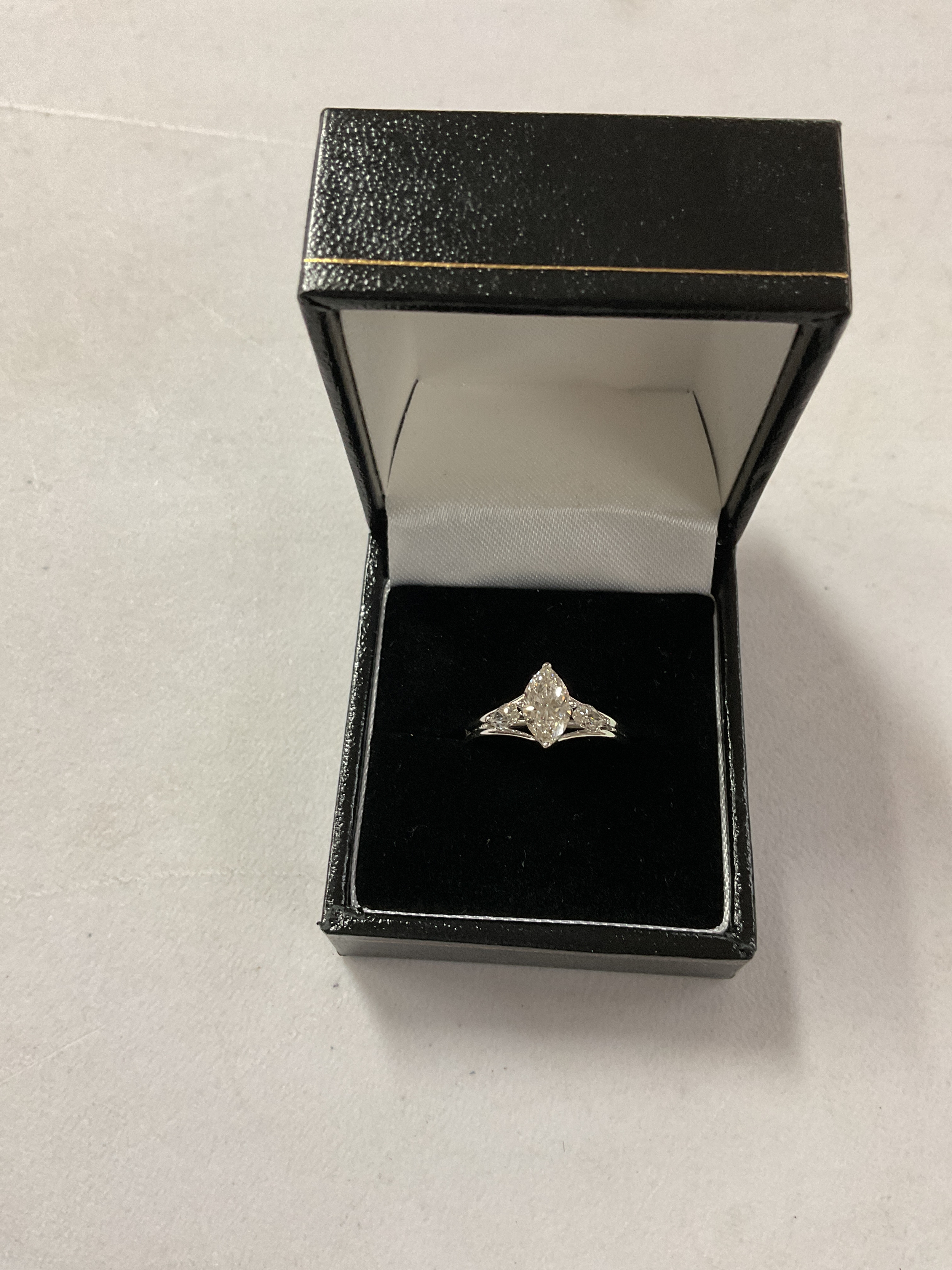 18 ct white gold Diamond solitaire ring, central Marquise Diamond 1.03 ct, and two 0.18ct Marquise Diamonds to the shoulders. Weight 4.3 grams, size N.total Diamond carat weight 1.39 ct.