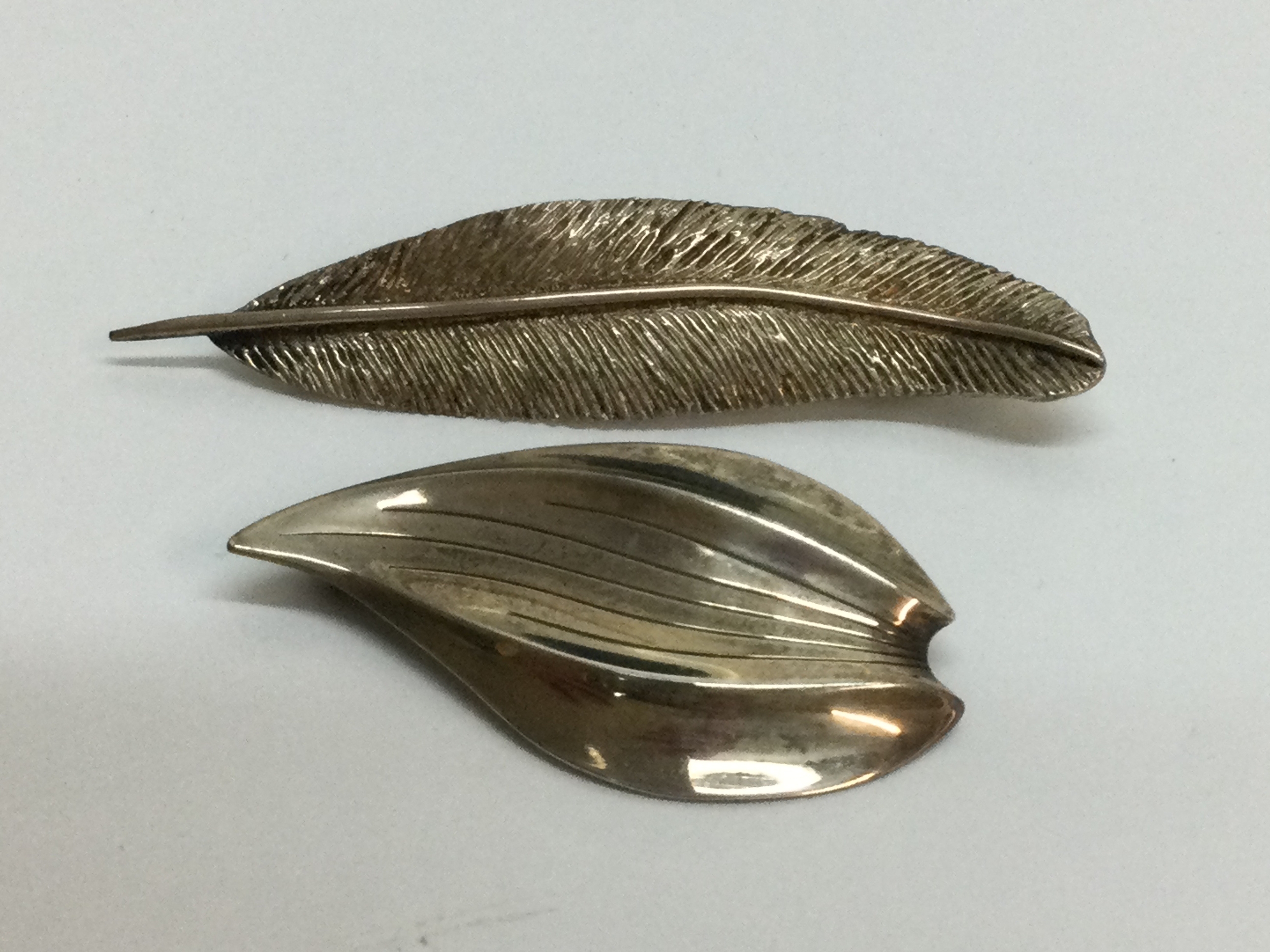 A Danish silver, Hermann Siersbol leaf brooch of modernist design, plus one other of similar type stamped 925. Approx 5.5 and 6.5 cm respectively.