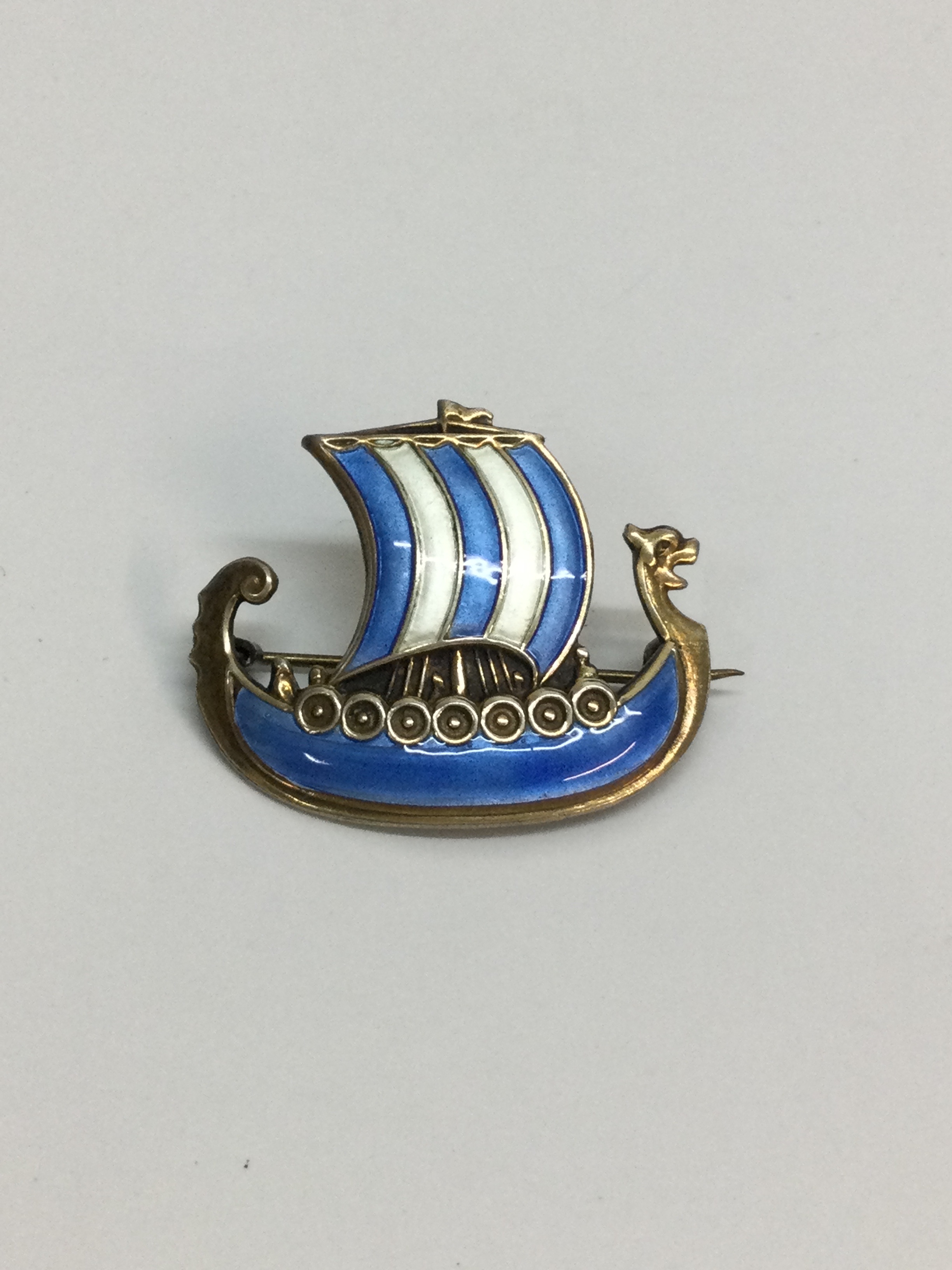 A Norwegian, Ivar Holth silver gilt and enamel Viking ship brooch. Approx 3cm.