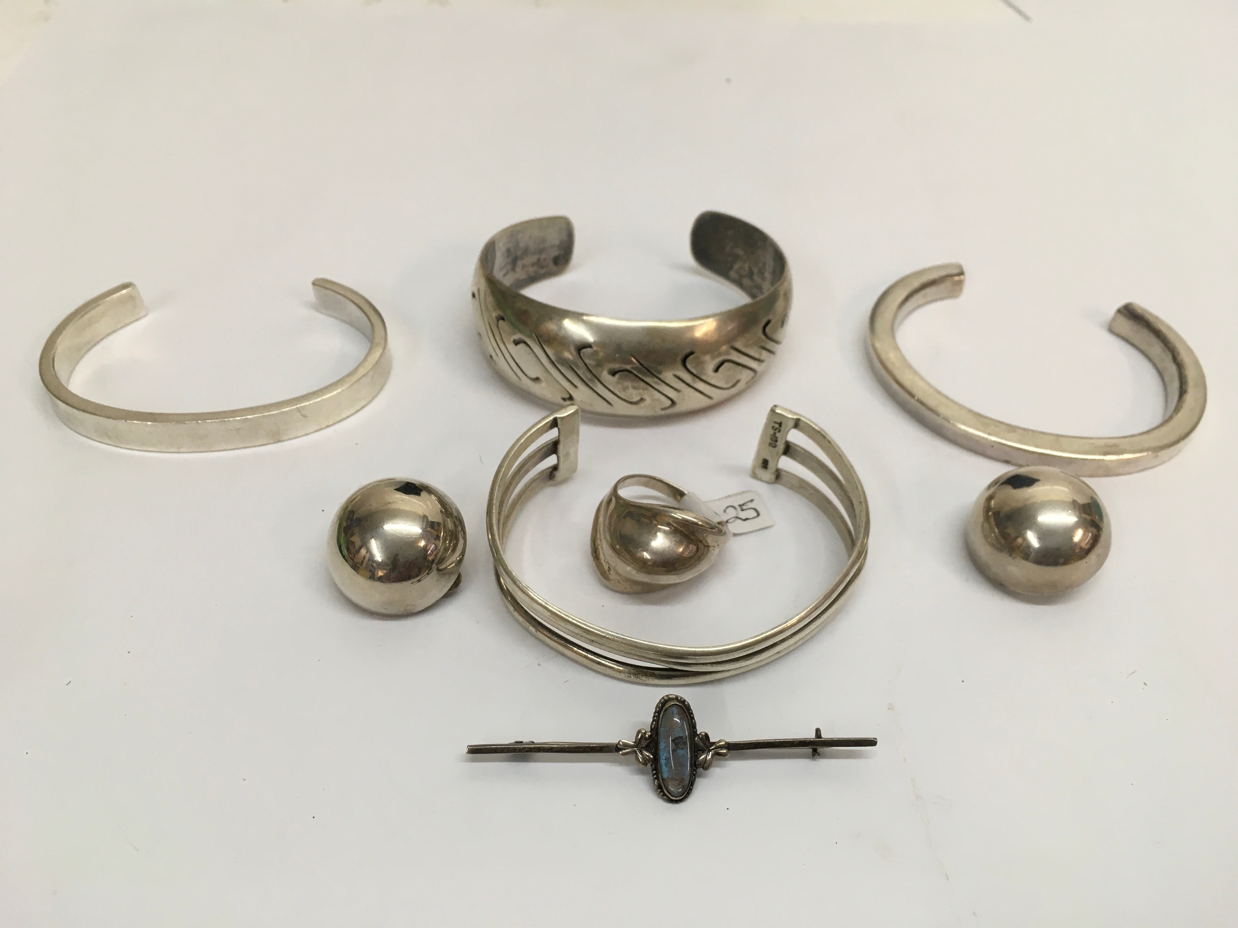 A small group of 925 silver and white metal jewellery including a Mexican cuff bangle, earrings and brooch. 