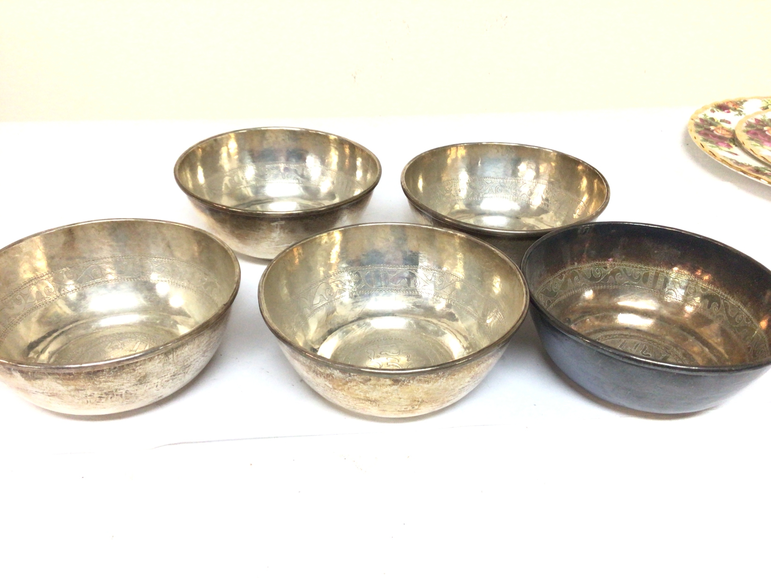  A set of five white metal bowls Middle Eastern engraved with a pattern and Middle Eastern script possible low grade silver 550g approximately. (5) 