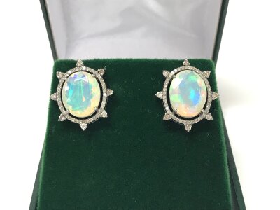 A pair of silver sunburst stud earrings set with oval opals and mixed round cut diamonds. 14ct yellow gold posts. Opals 7.70ct and diamonds 0.77ct.