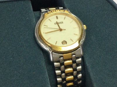 A Gucci 8000M mid size wrist watch in a citizen eco drive box display
