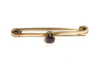 A 15ct gold Barb brooch set with a pigeon blood ruby, approx 2.8g.