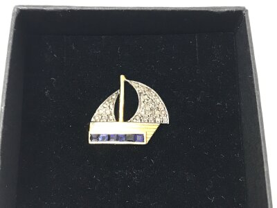 Sailing boat tie pin in silver gilt with diamonds and sapphires.
