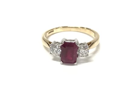 9ct yellow gold and white gold trilogy ring set with a central step cut Ruby flanked by diamonds. Ruby 1ct approx and 0.43ct diamonds.