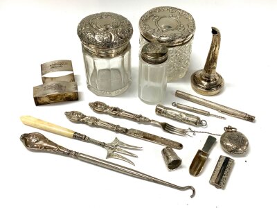 A mixed lot of hallmarked silver articles to include silver topped tidys, Sovereign case, wine funnel etc…