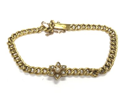 A 15ct gold bracelet set with seven real pearls in a floral cluster on a hollow curb link bracelet pre 1934