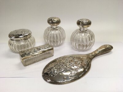 A five piece silver dressing table set with floral decoration, Birmingham hallmarks.