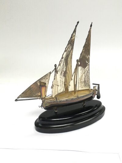 A small silver model of a sailing boat, approx height 15cm.