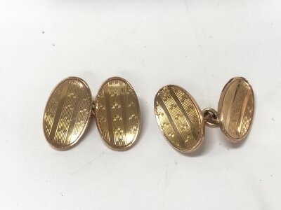A pair of 9ct gold oval concaved engine turned cuff links with chain connections by Henry Griffiths & Son Chester 1912. 8.83g