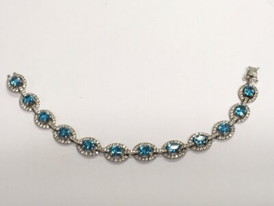 A 14ct white gold diamond and blue topaz bracelet. 18.7g