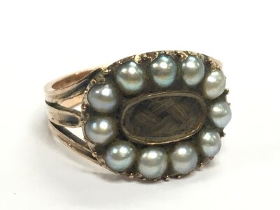 A 19th century unmarked gold mourning ring set with pearls, size N. 4.3g