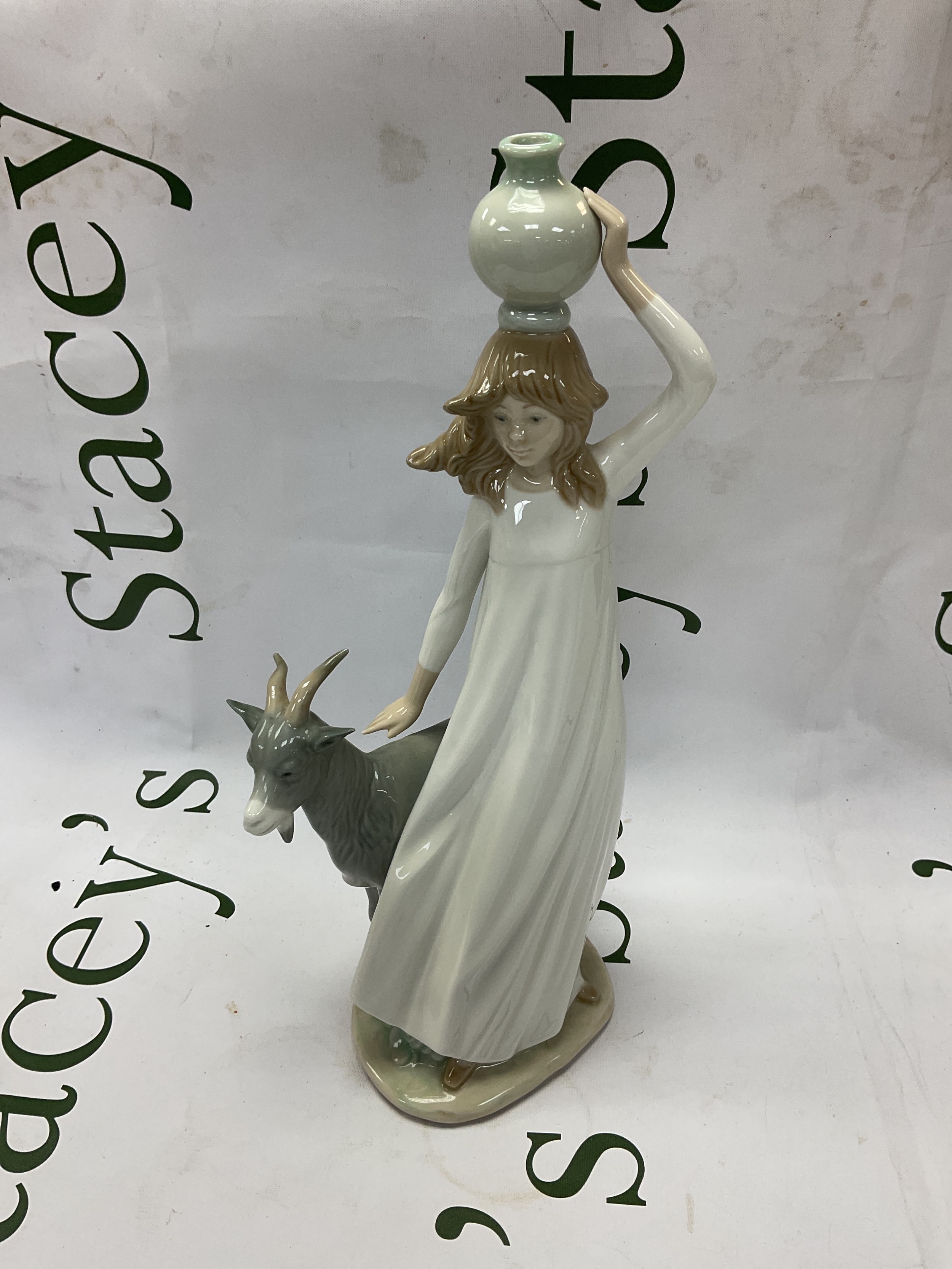 Nao figurine of girl carrying water with a goat.