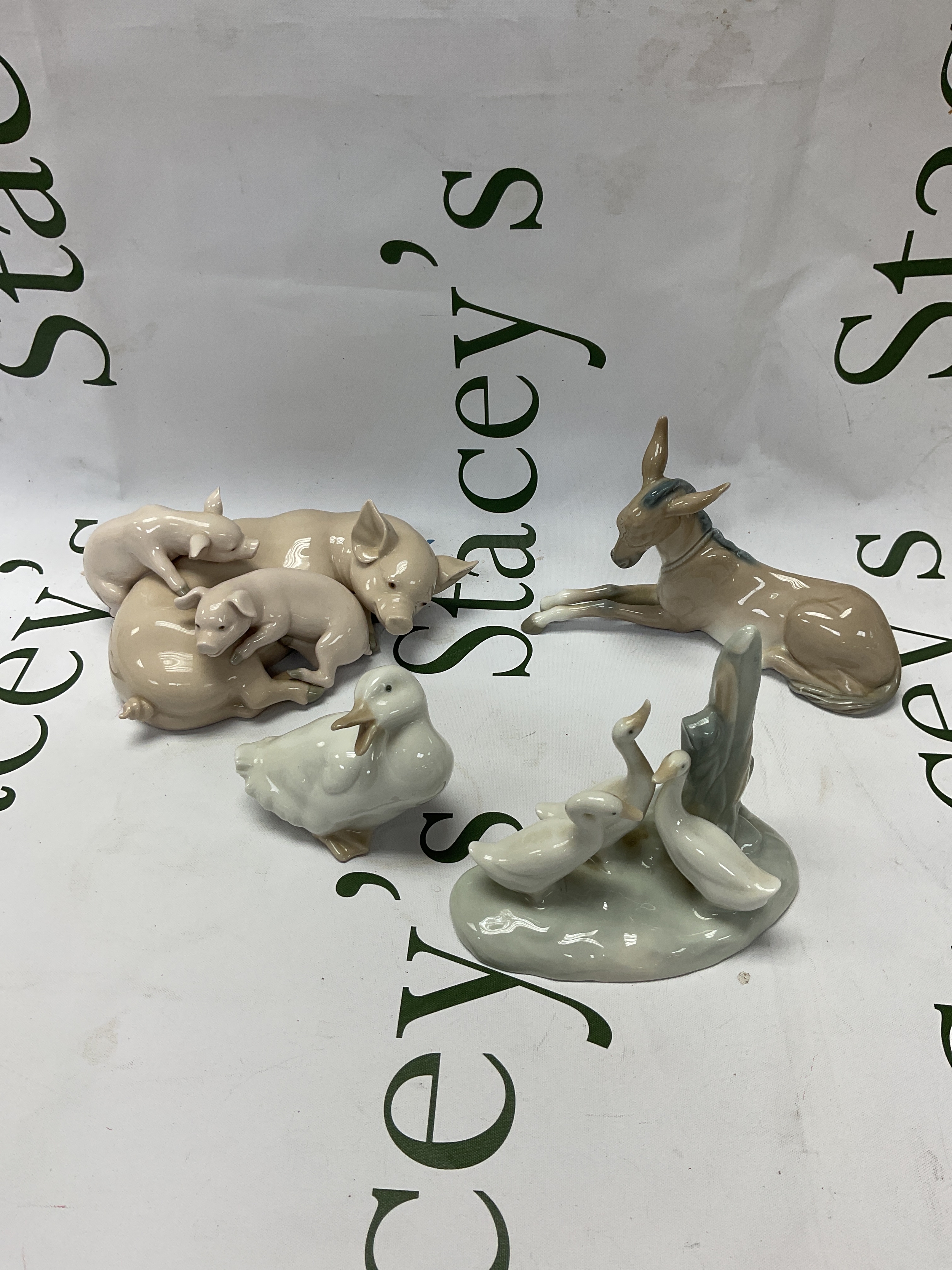 Lladro pigs and donkey along with two NAO duck figures.