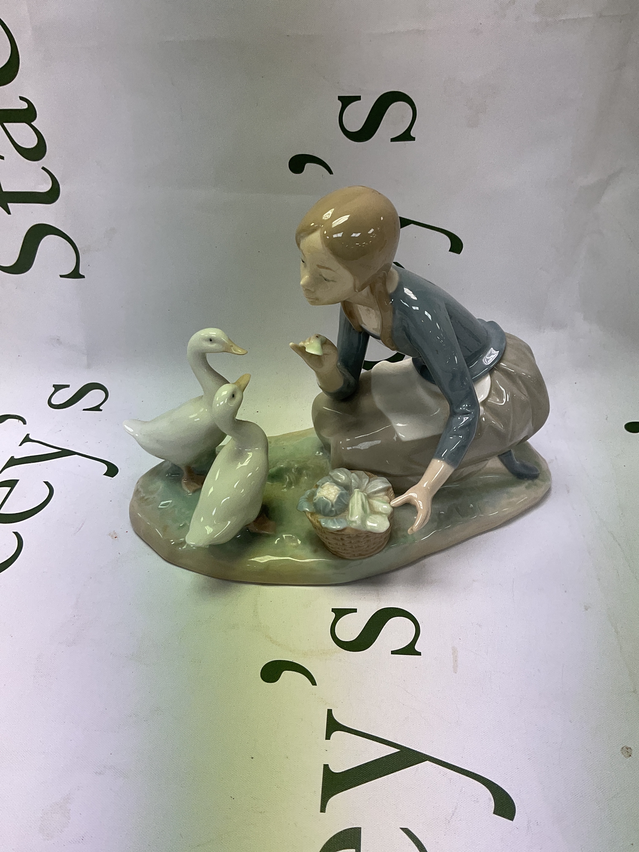 Lladro figurine of a girl feeding ducks.