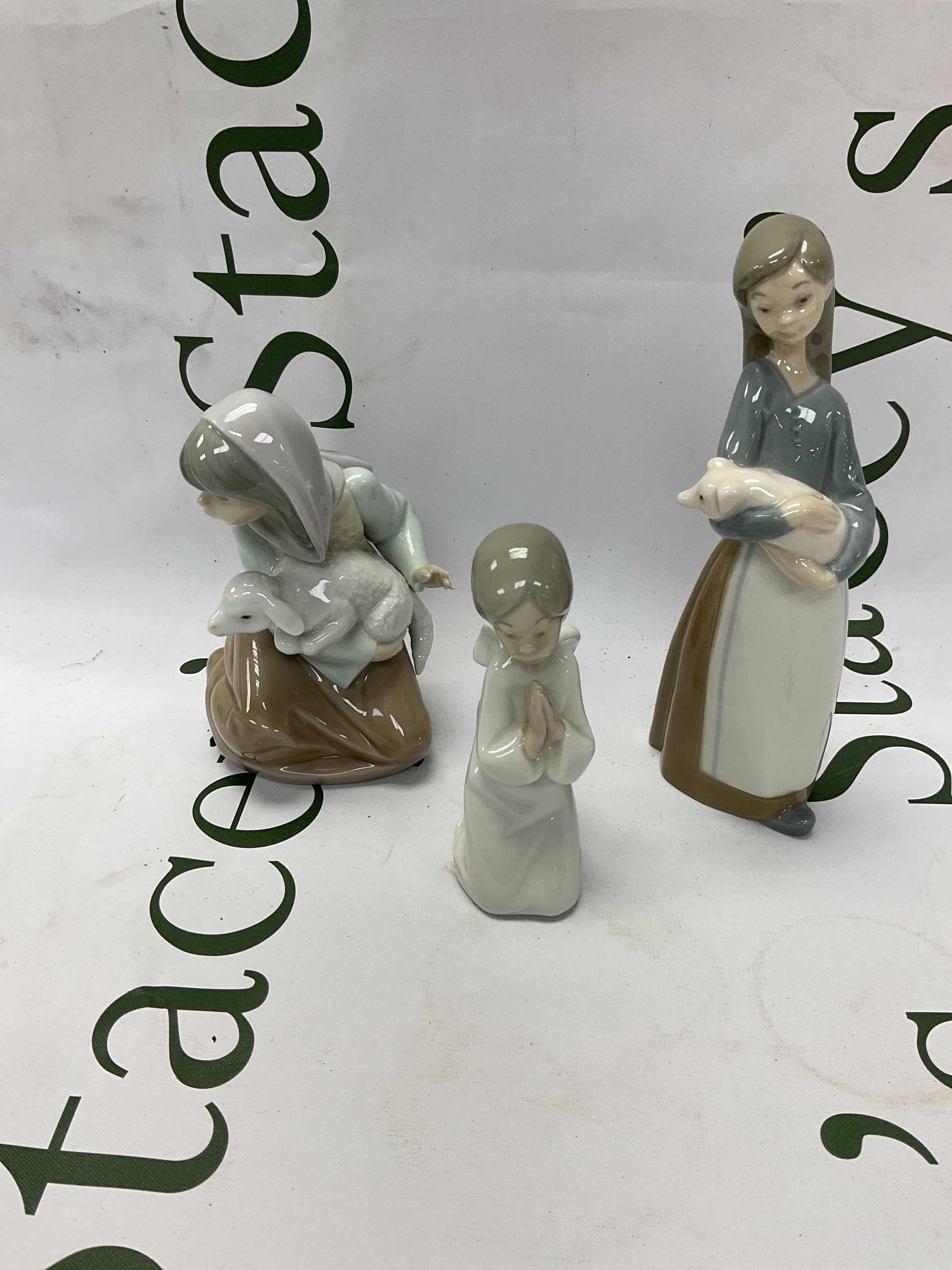 Two Lladro figures and a NAO angel.