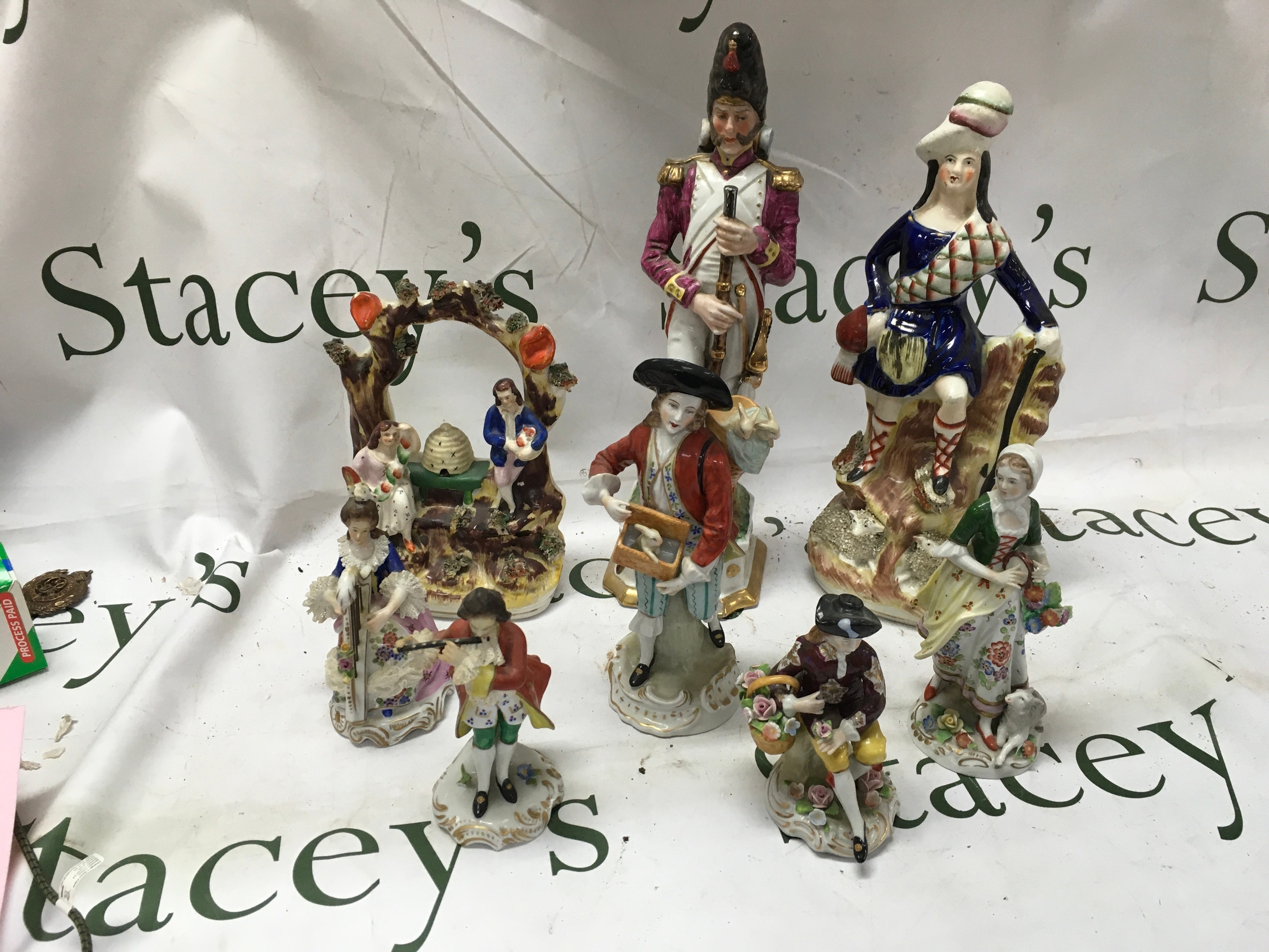 Eight 19th C figurines, to include Sitzendorf pair of musicians 13 cm, man with flower basket 12 cm, woman with tambourine and lamb 16cm, man with rabbits 19cm, two flat-backs and a Napoleonic soldier with restoration to his neck 30cm. NO RESERVE