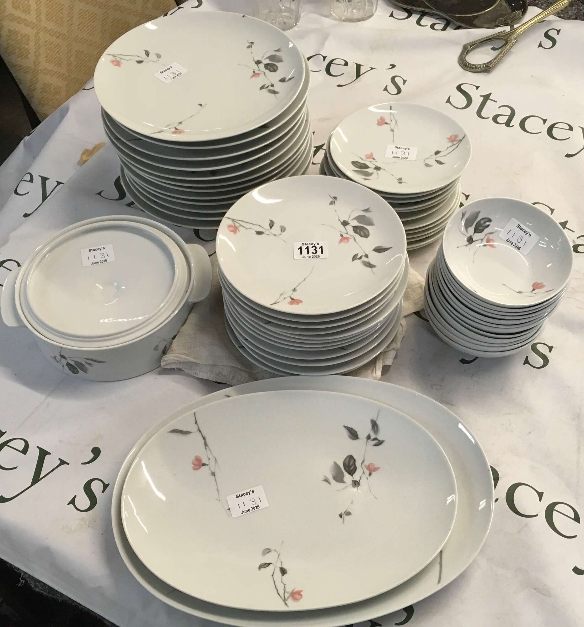 A set of ceramic table equipment. The patterns feature delicate, stylised grey branches and leaves bearing minimalist coral blossoms reaching across a clean white ceramic glaze NO RESERVE