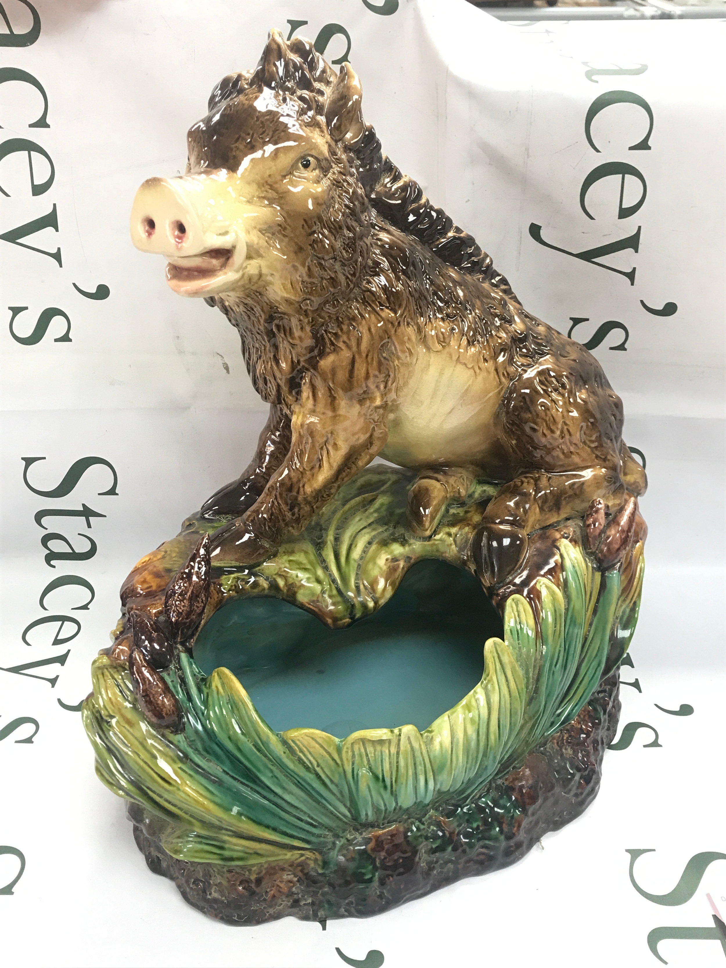 A reproduction french majolica earthenware planter, wild boar sited on the edge of a flower pot decorated with reed motifs. 42cm tall
