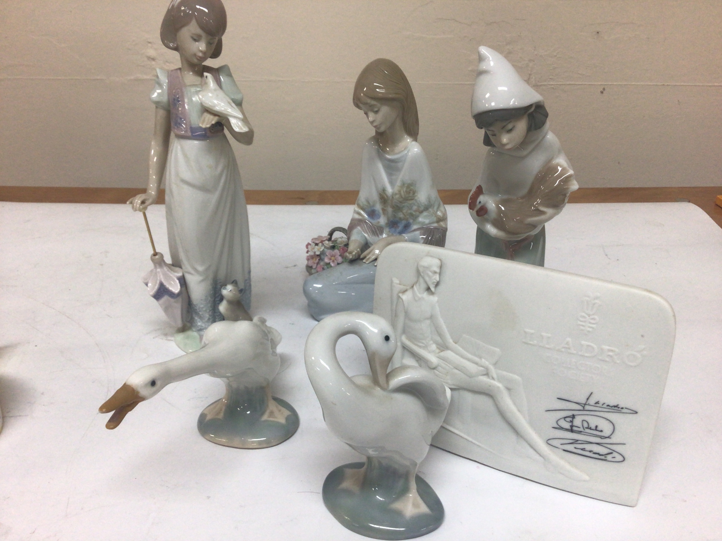 A collection of Lladro figures in the form of children with a dove a girl with a basket of flowers signed base two Ducks and a Lladro Collectors Society plaque. No obvious damage.
