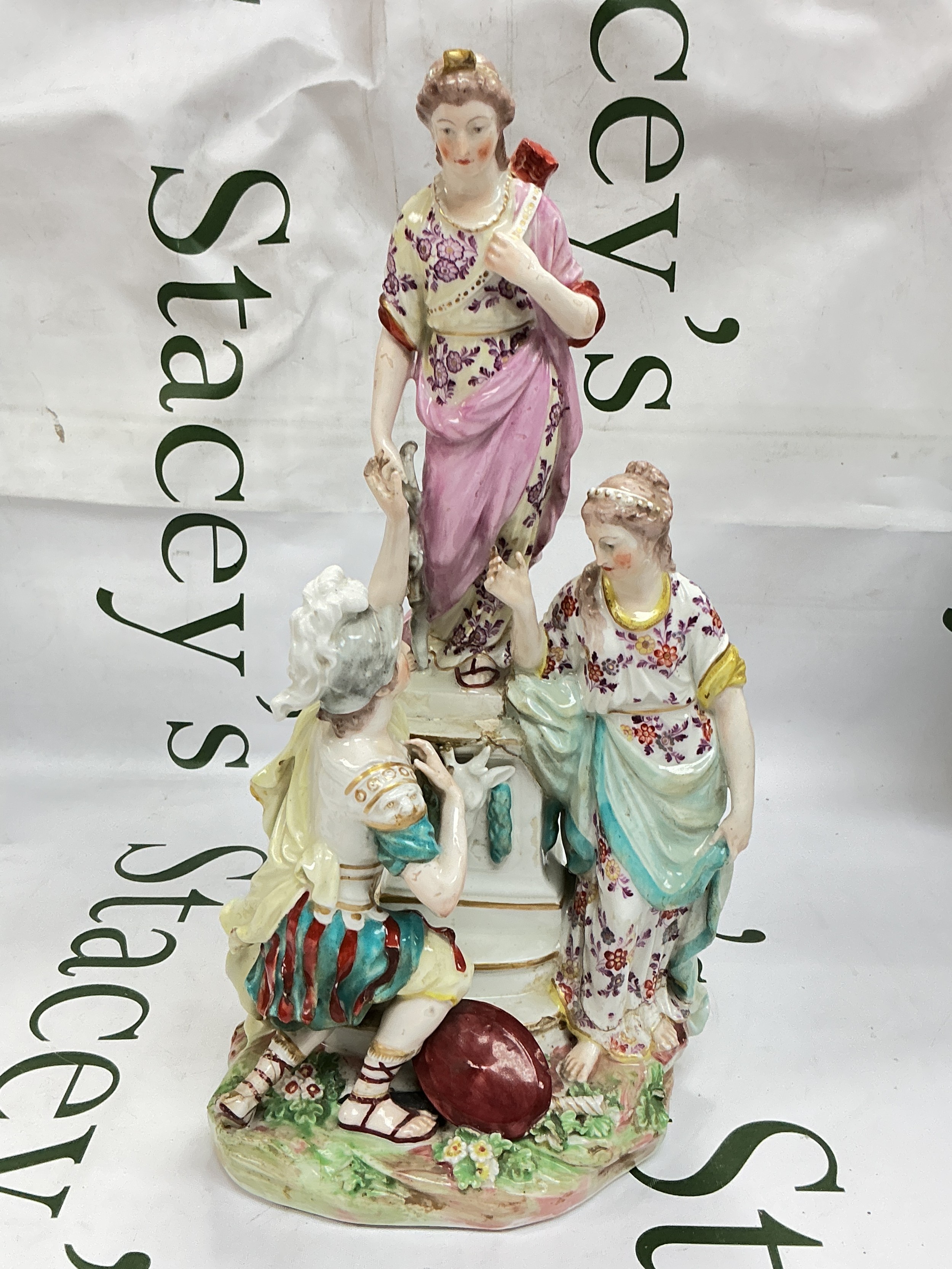 A Derby porcelain figural group depicting Jason and Medea at the Altar of Diana, circa 1770/80, with gilt enriched naturalistic enamelled decoration, raised on a floral encrusted mound base, incised shape No. 37 to base, approx height 31cm. Restored with some losses.