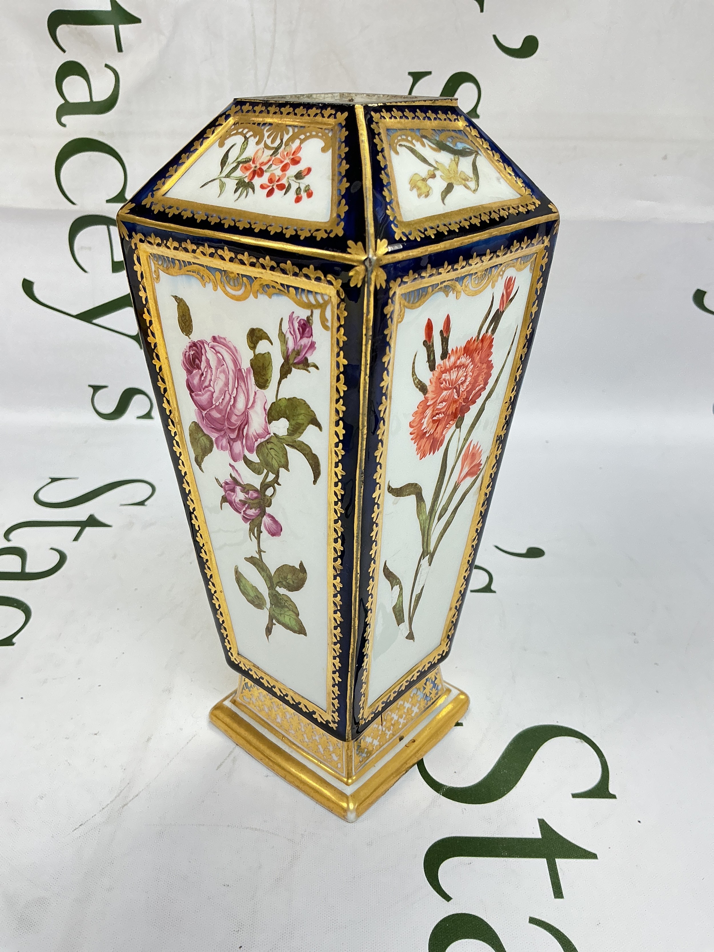 A Chelsea porcelain tapered vase decorated floral panels with Mazarin blue and giltwork details. Gold anchor mark to base. Approx height 20cm.