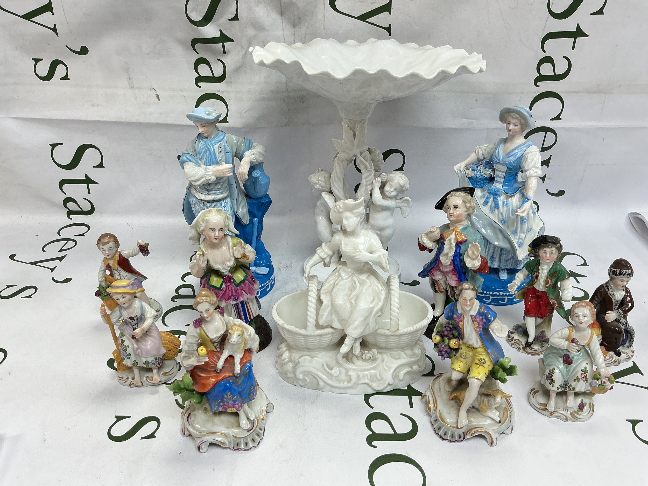 A collection of various Continental porcelain figures plus a Copeland Spode blanc de chine comport decorated with putti.