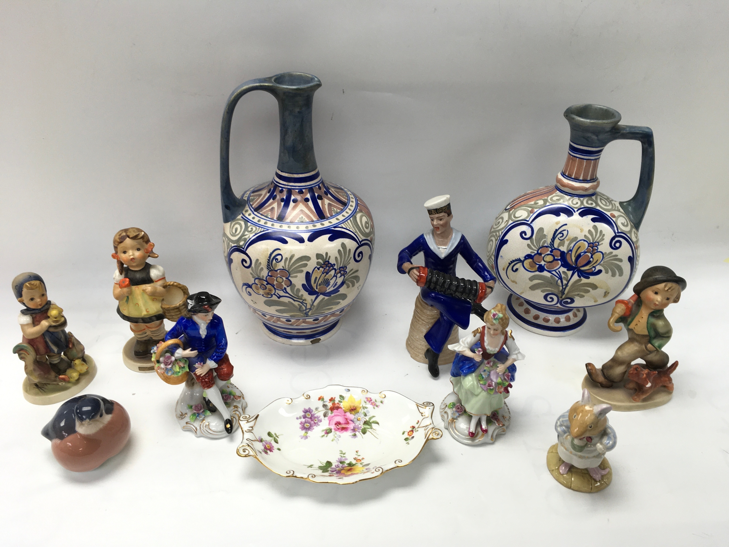 A small collection of ceramics including Gouda jugs and a Dresden sailor figure